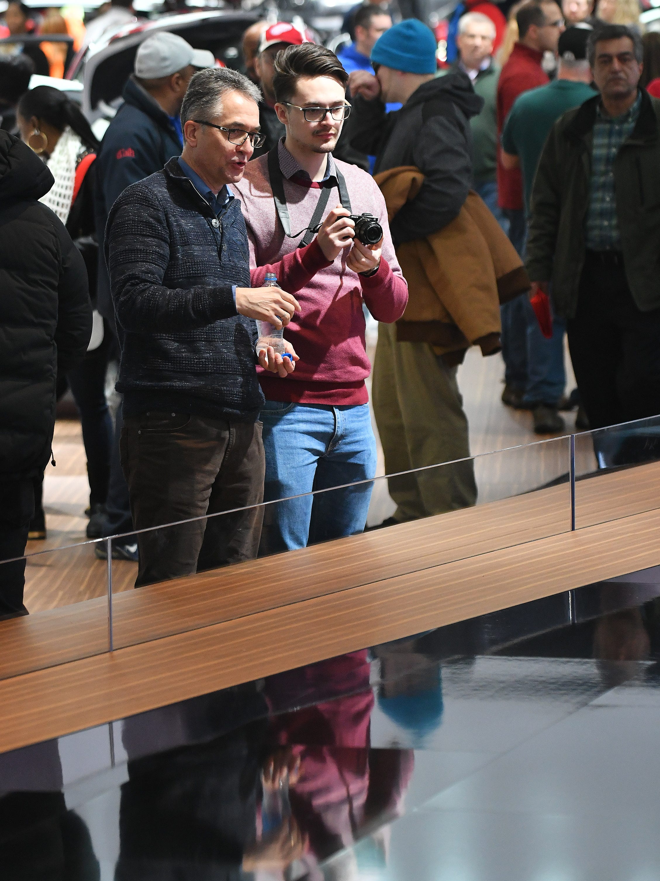 Dieter Hirmke, left, and his son, Sebastian Hirmke look at the Infiniti display.