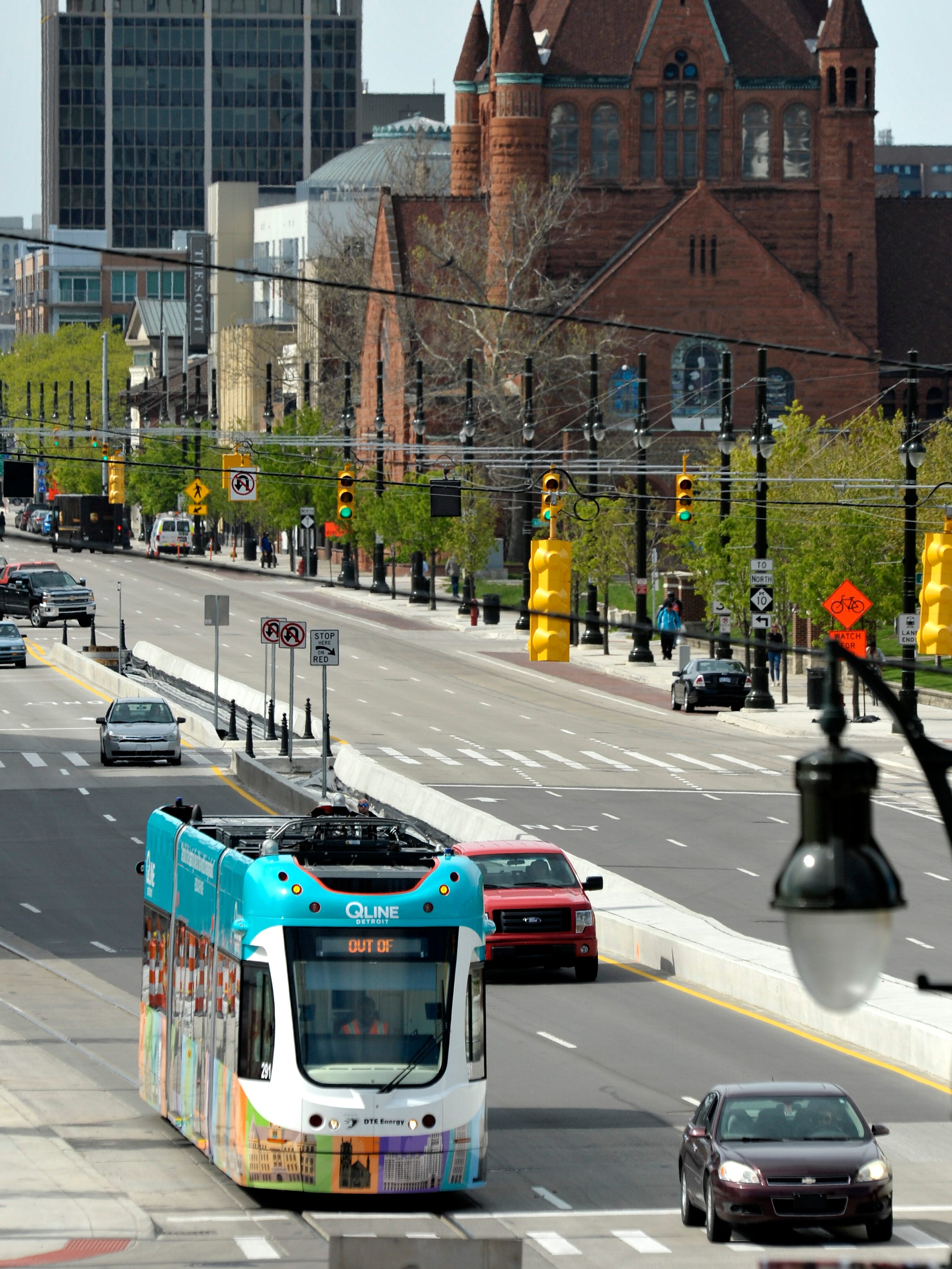 A QLine Detroit streetcar waits at a traffic light on the Woodward southbound bridge over Interstate 75.