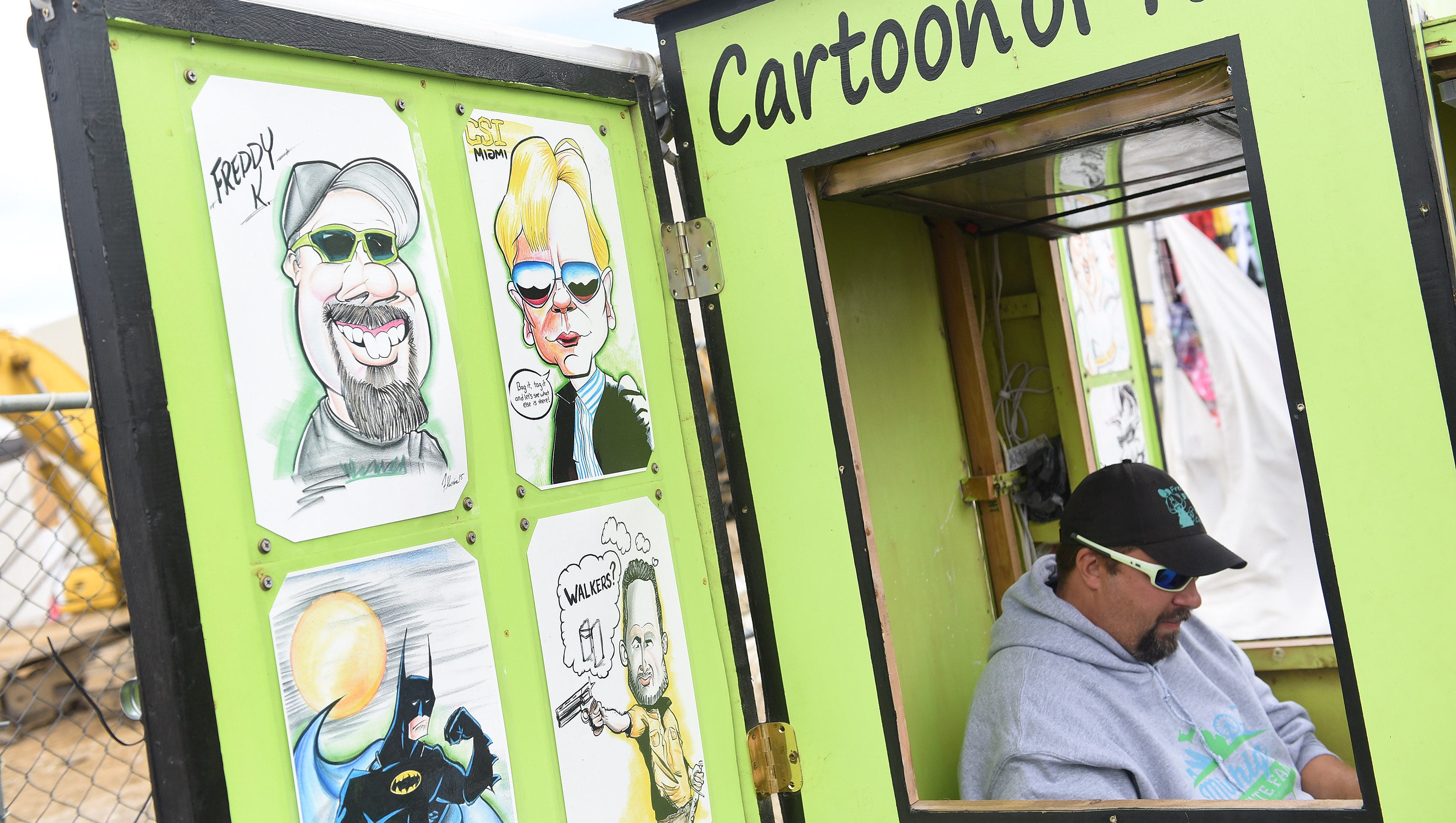 Freddy Koceba of Port Austin works on a caricature drawing at his booth.