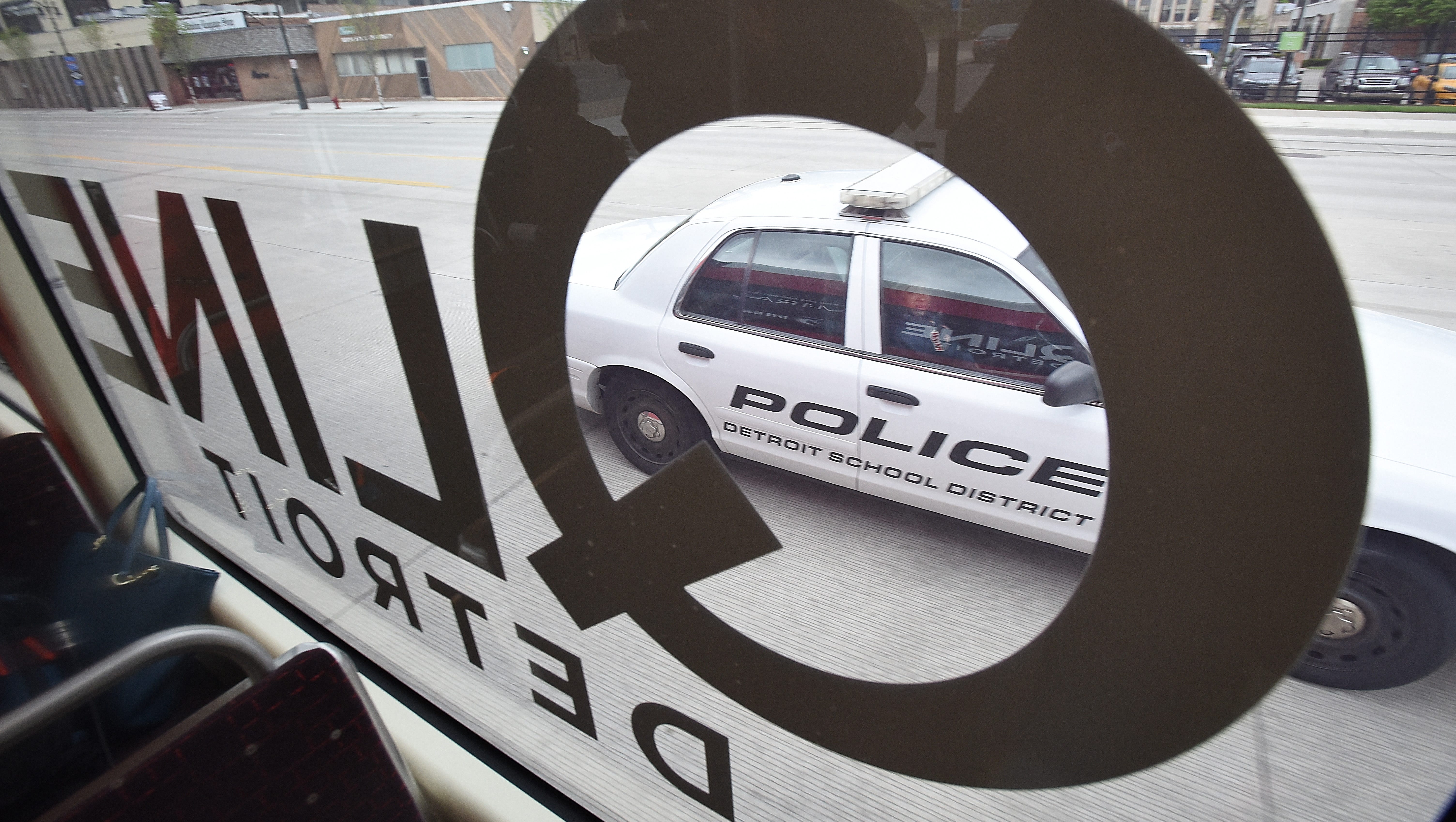 A Detroit School District police car passes by the Q-Line rail on Woodward Ave. near the campus of Wayne State University.