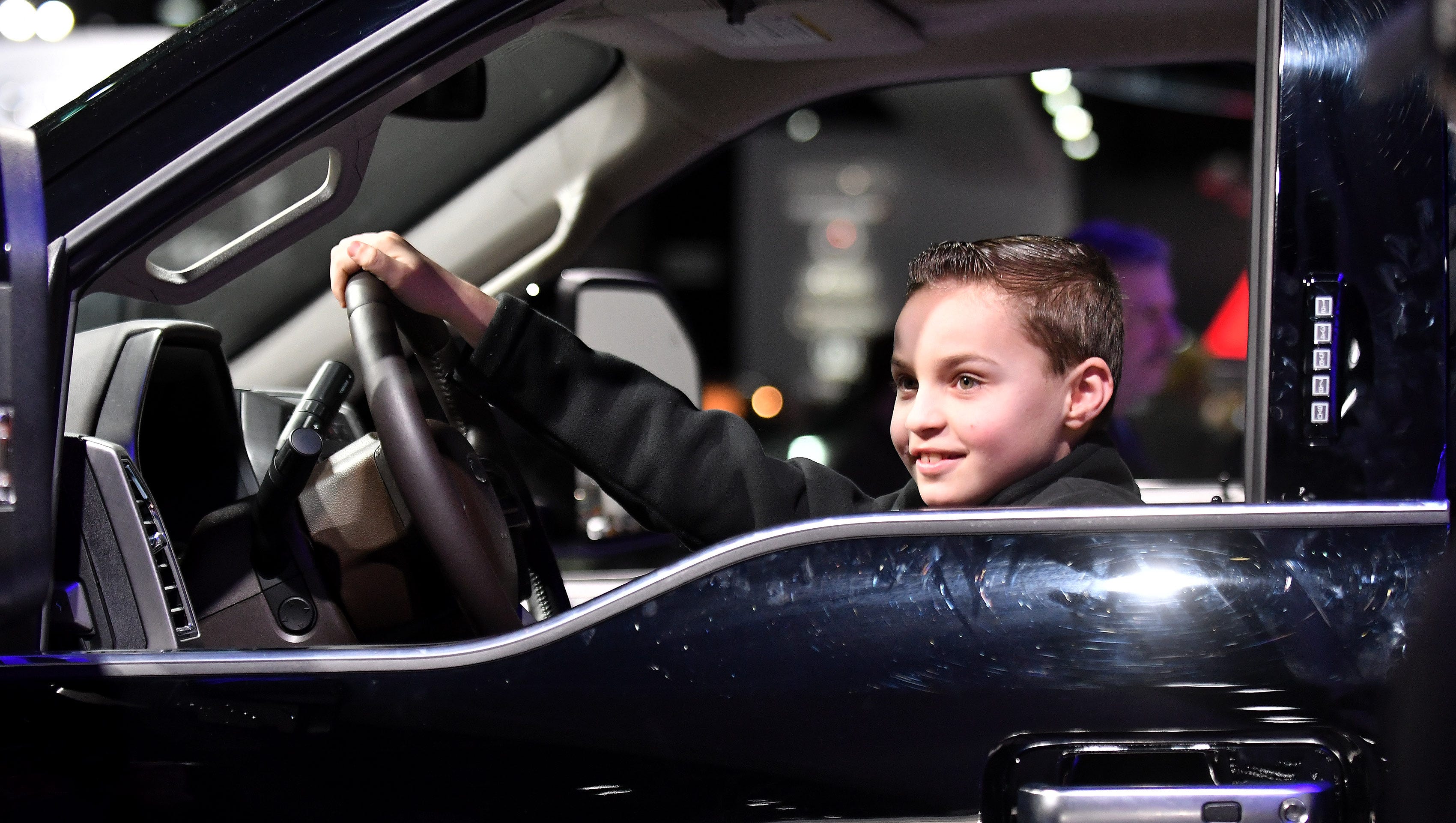 Anthony Ballarin, 8, of South Lyon sits in the Ford F-450 superduty truck while his dad, Wayne Ballarin, takes a photo.