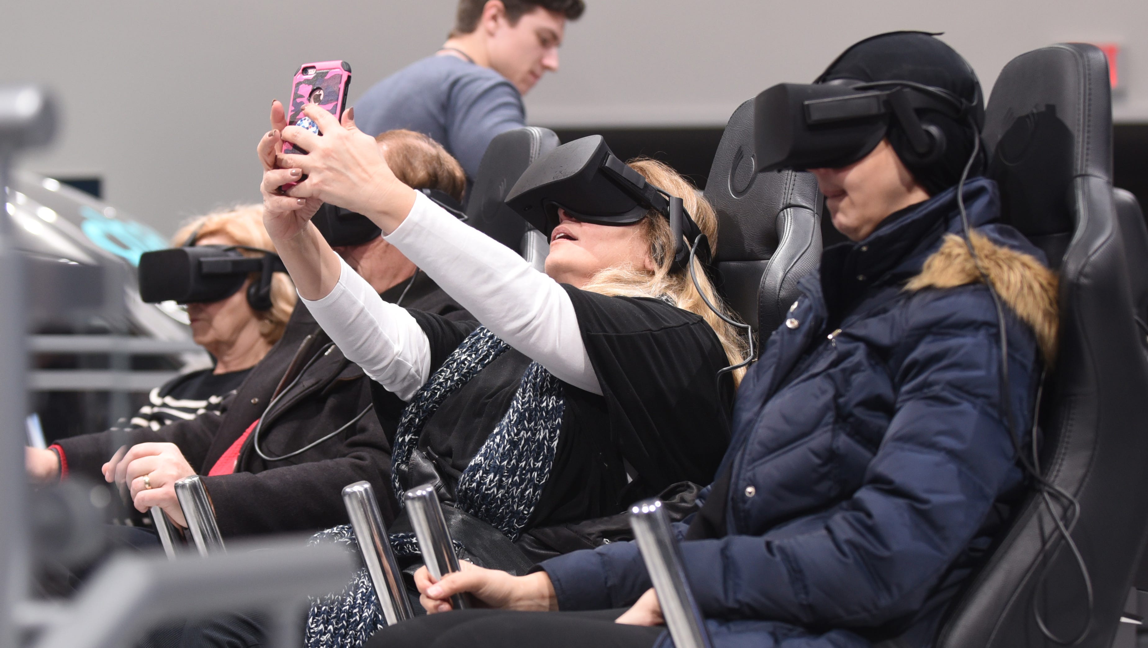Alia Abourass, of Syria, dons a headset and takes a selfie during the Ford Motor Company's Future Mobility VR Experience on Saturday January 20, 2018 for the first public day for the North American International Auto Show