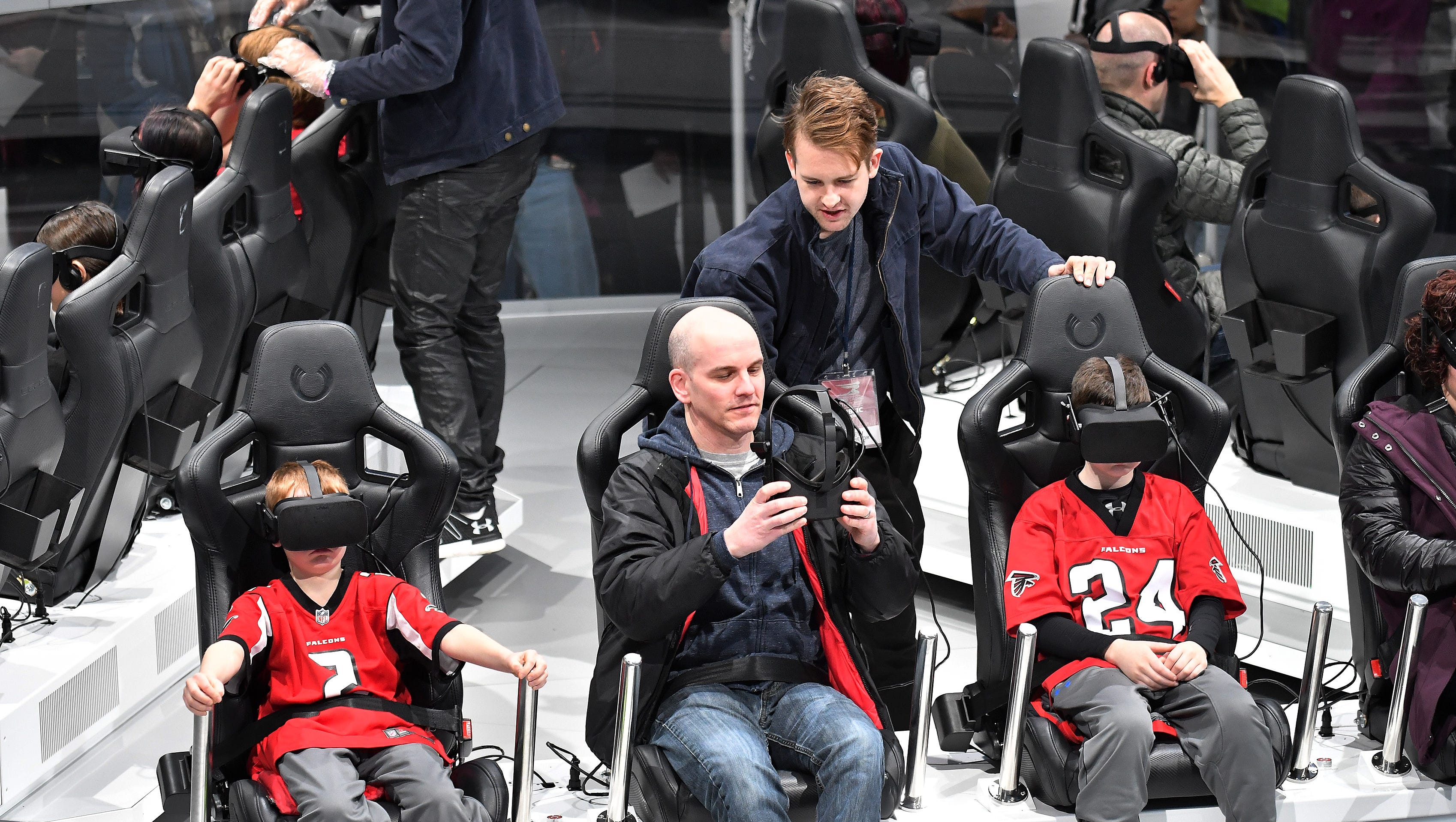 Ford brand ambassador Drew Batchelor talks with Mike Blumenstein with his sons, Ben Blumenstein, 10, left, and Brandon Blumenstein, 11, right, at the Ford future mobility virtual reality experience.