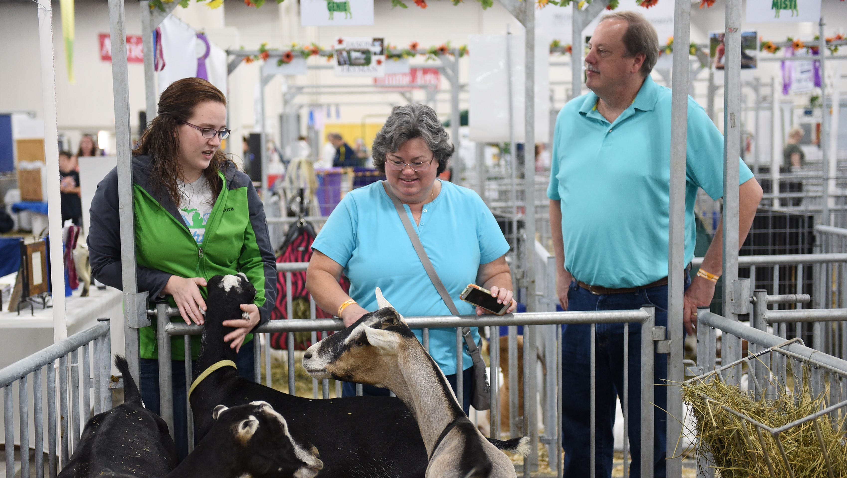 Laura Coon of Udderly Nutz Dairy Goats, left, talks with Laurrie Bissinger and Noel Bissinger of Lansing at Laura's display.