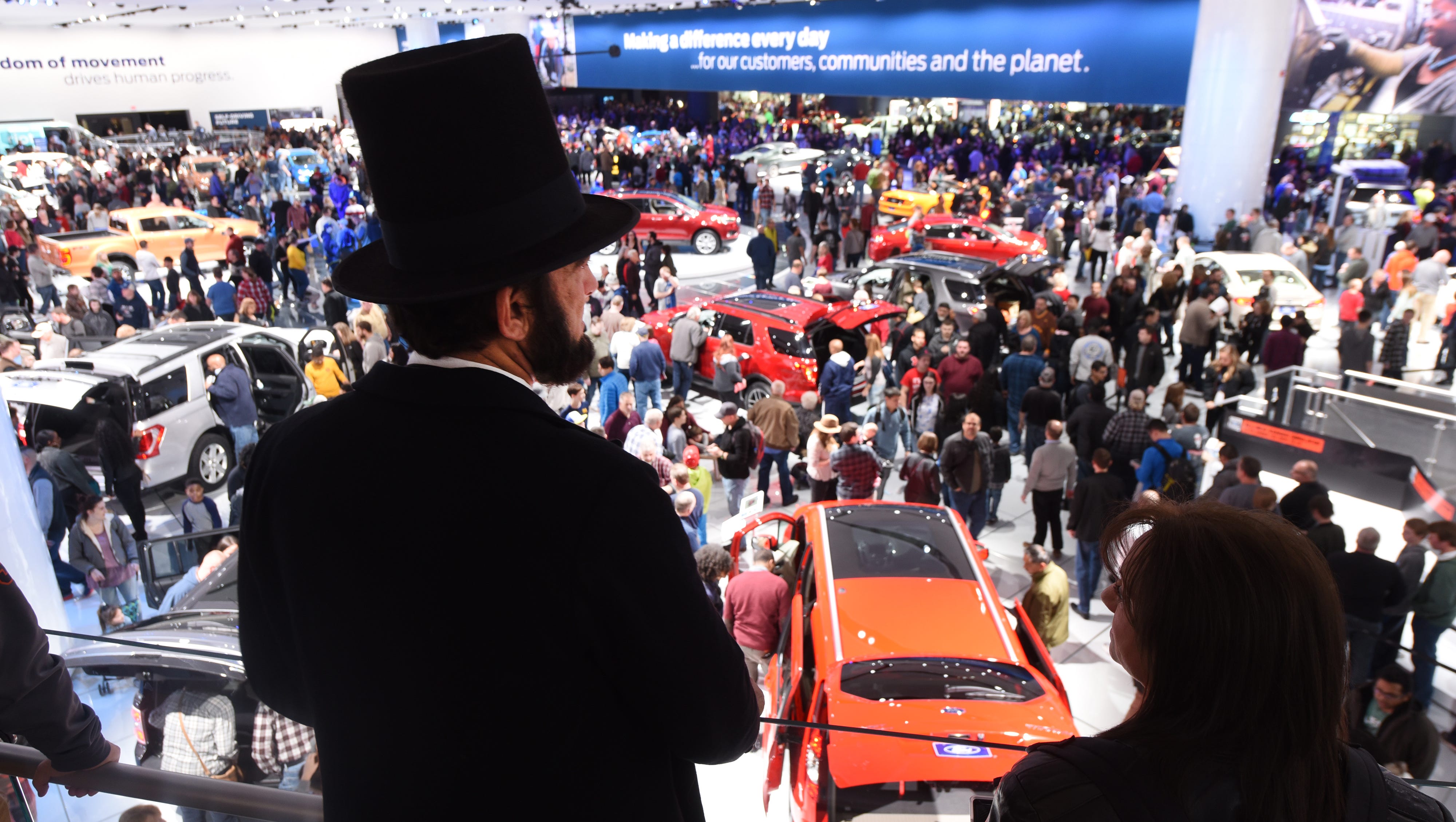 Ron Carley, professional Abraham Lincoln presenter, dons a signature top hat at the Ford Motor Company display .