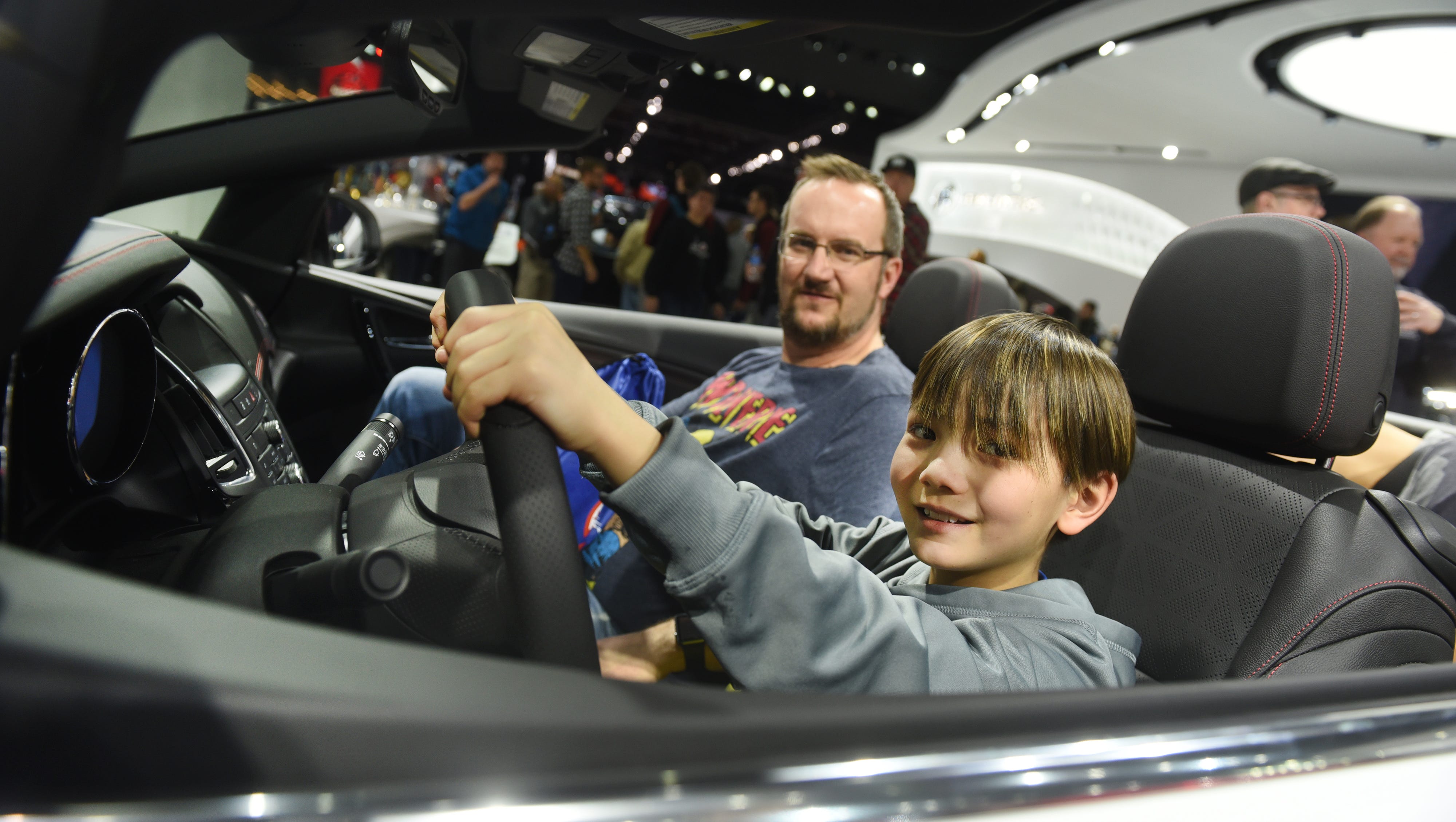 Dawson Brown, 11, of Warren , Ohio, sits in the driver's seat with his father Darrin in a 2018 Buick Cascada on Saturday January 20, 2018 for the first public day for the North American International Auto Show