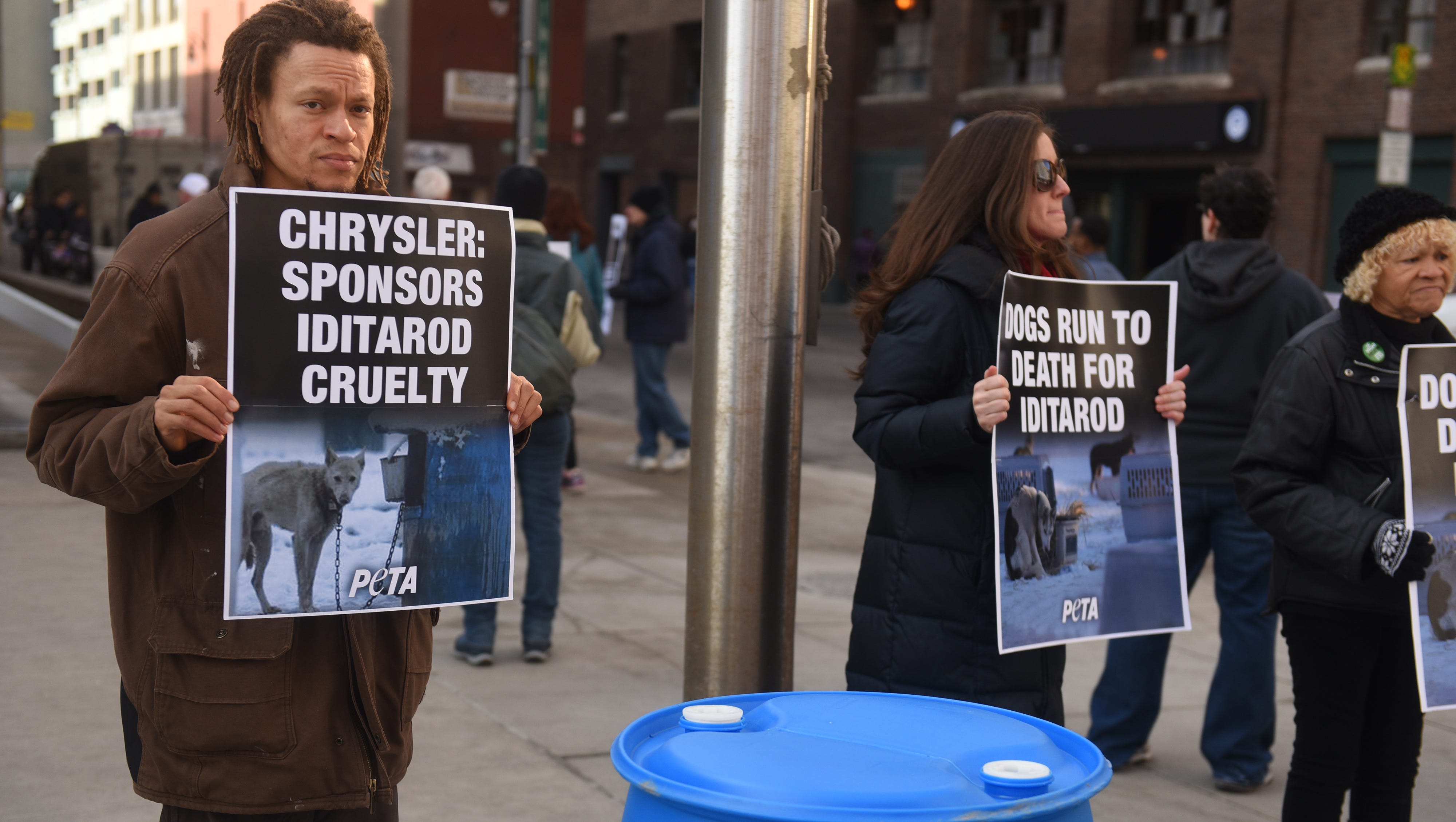 Members of PETA carry signs and protest outside Cobo Center for the North American International Auto Show on Saturday January 20, 2018.