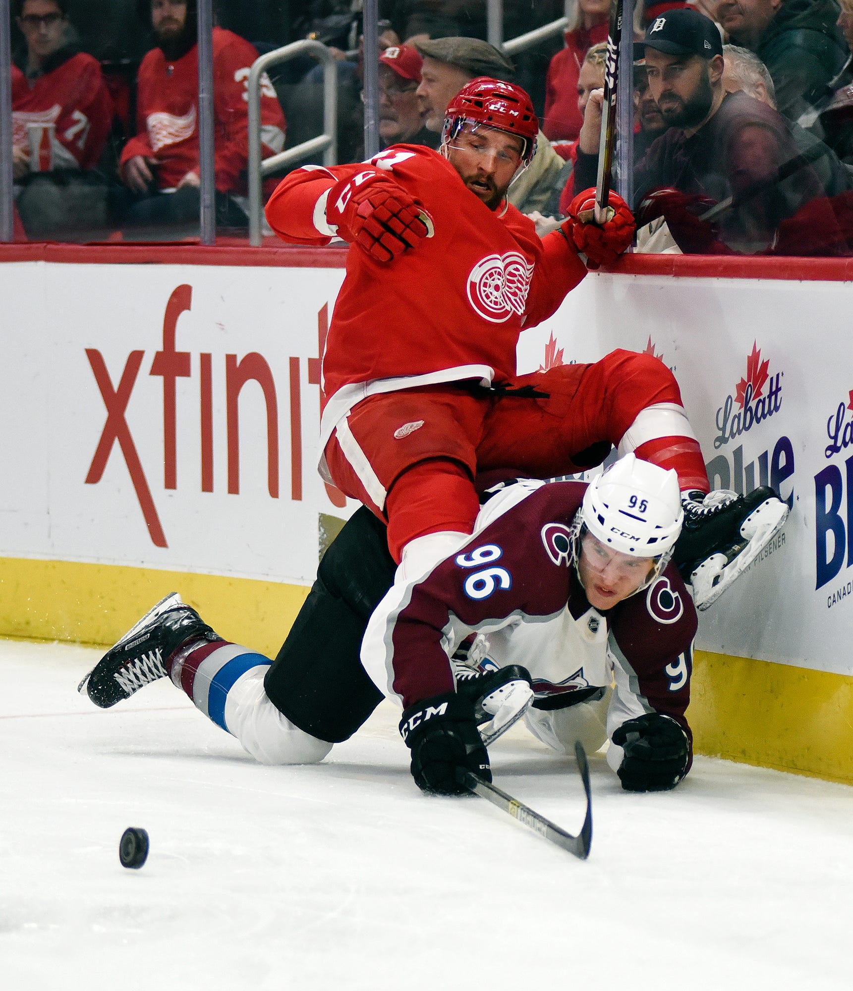 Red Wings center Luke Glendening, top, falls atop of Avalanche right wing Mikko Rantanen during the first period.
