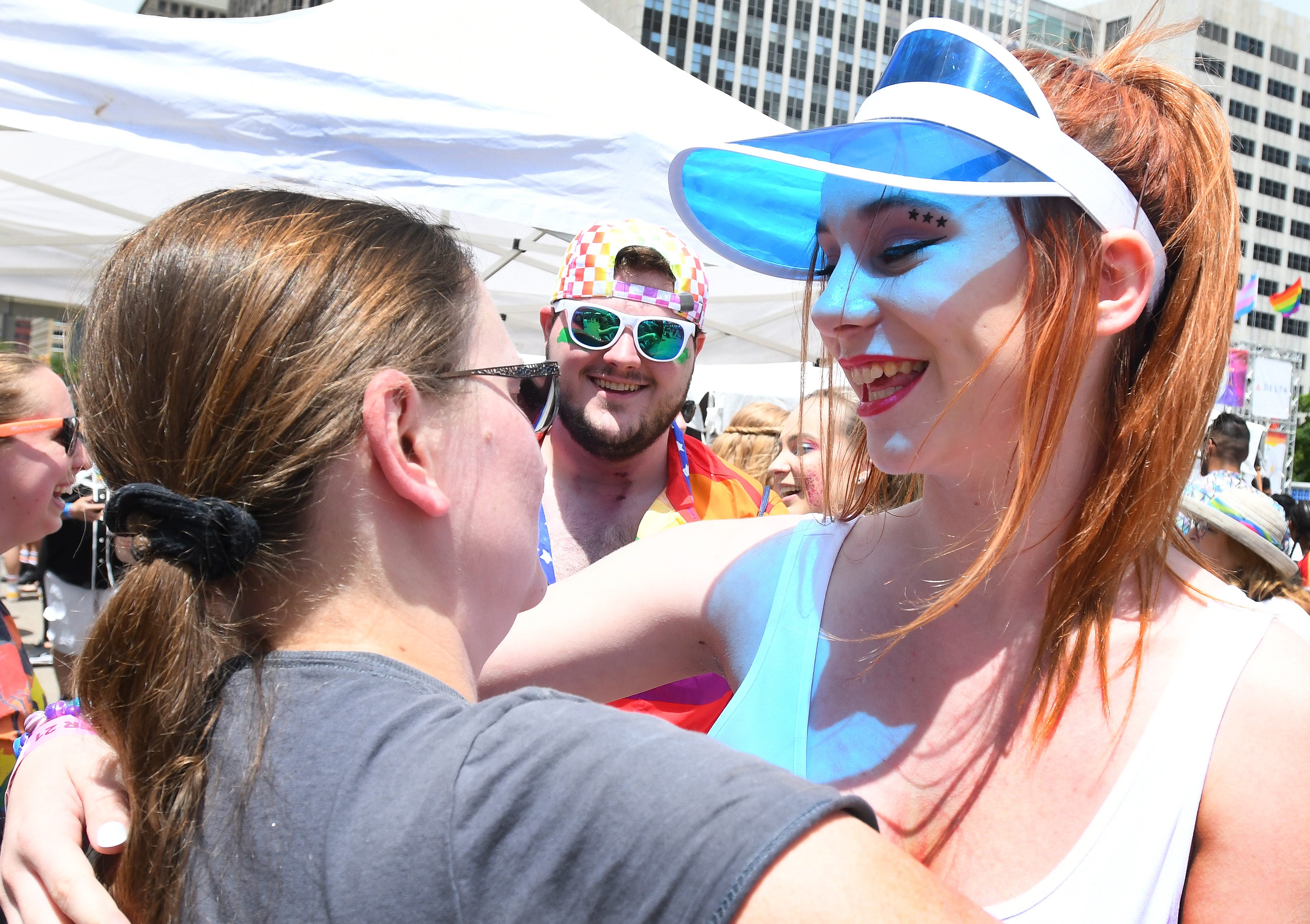 Alex Rogosch and Jessie Miller get free hugs from Robin Hudson-Ferzo of Dearborn First United Methodist as they enter the Motor City Pride festival on Saturday in Hart Plaza in Detroit.
