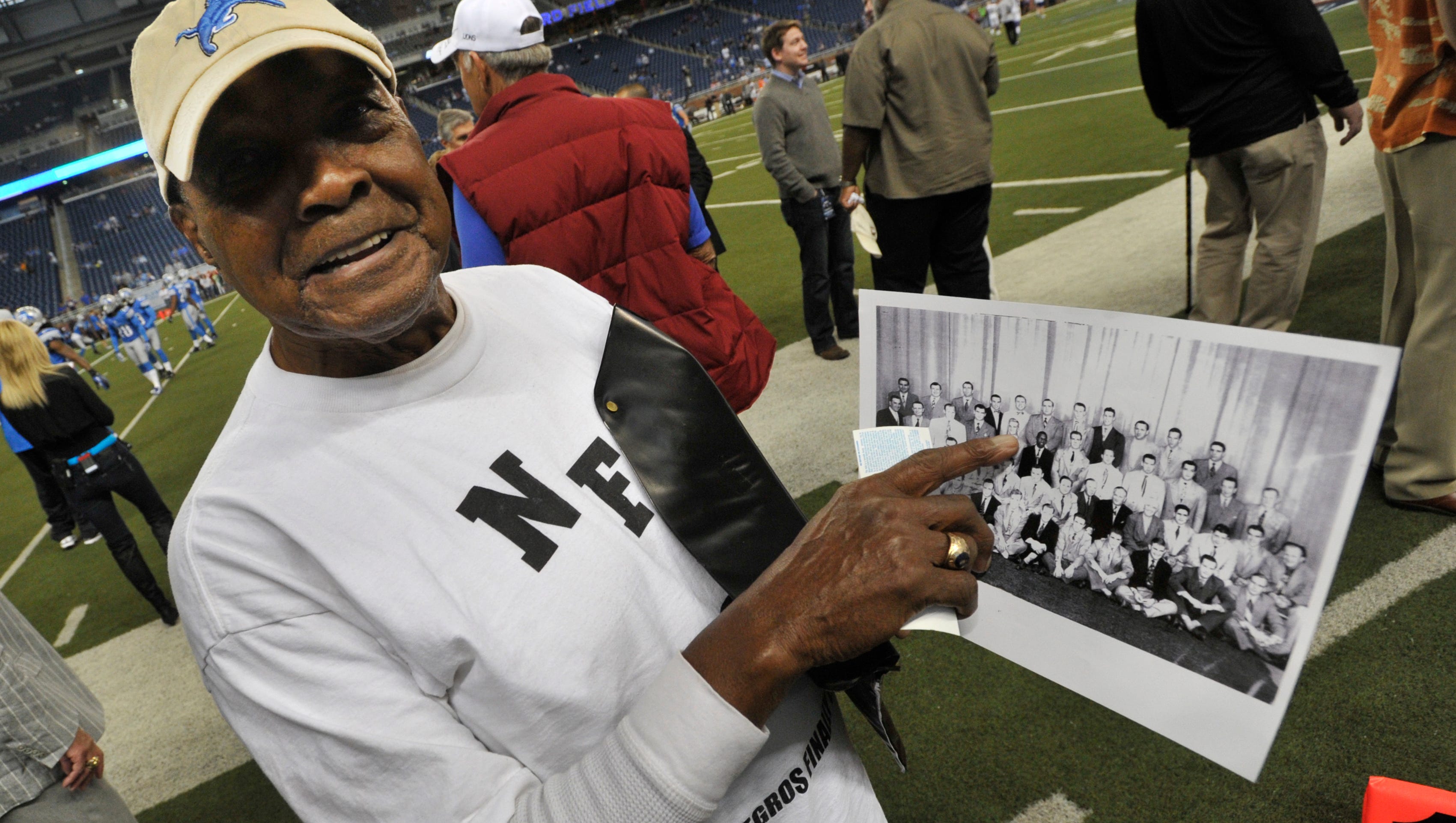 Wally Triplett shows off the 1950 Detroit Lions organization team picture on the sidelines of the game before Detroit takes on the Minnesota Vikings at Ford Field in Detroit, on September 30, 2012.  When  which player he was, he smiled and said, "This was 1950 son, I was the black player."