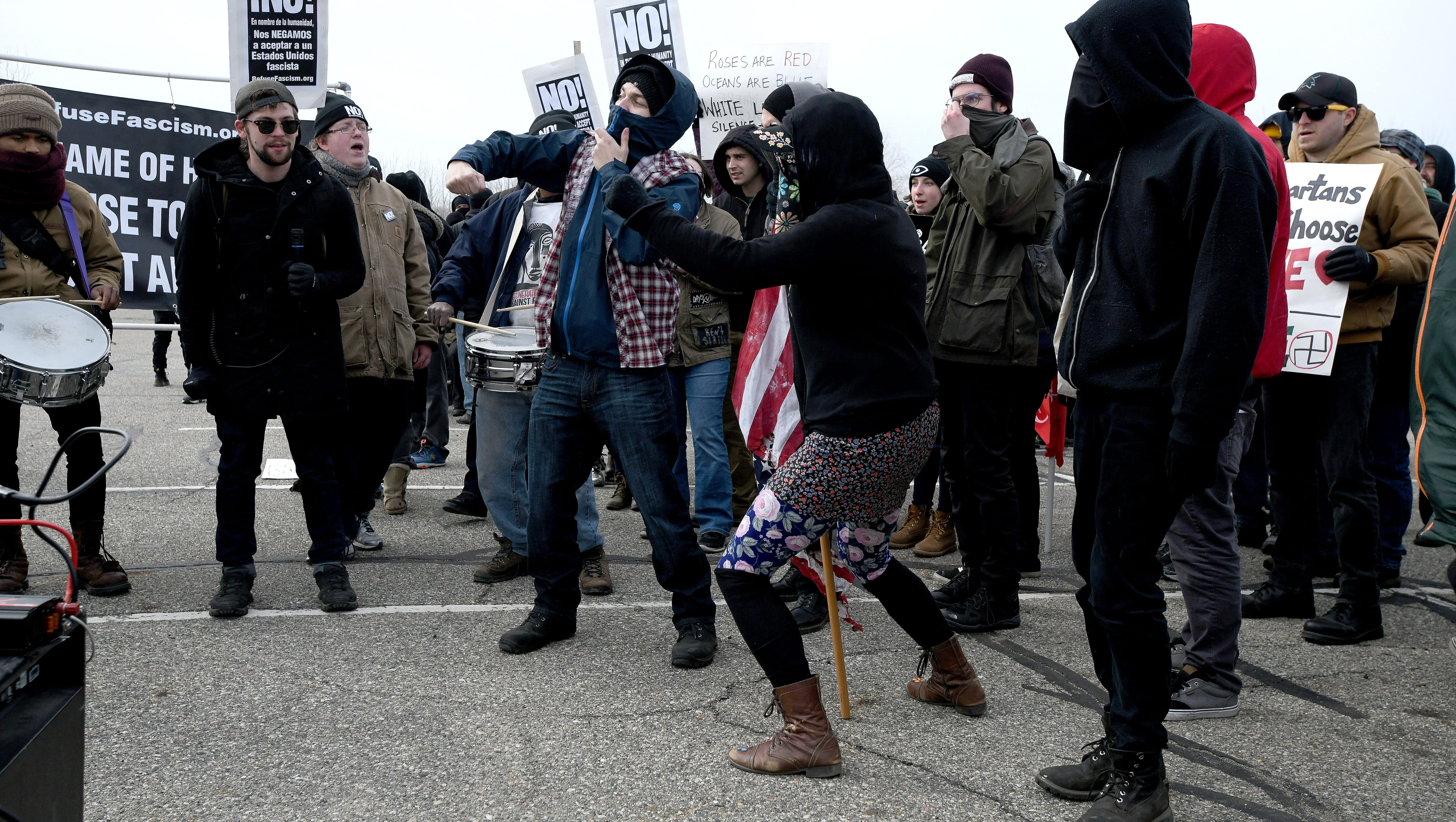 People demonstrate with a burned U.S. flag.