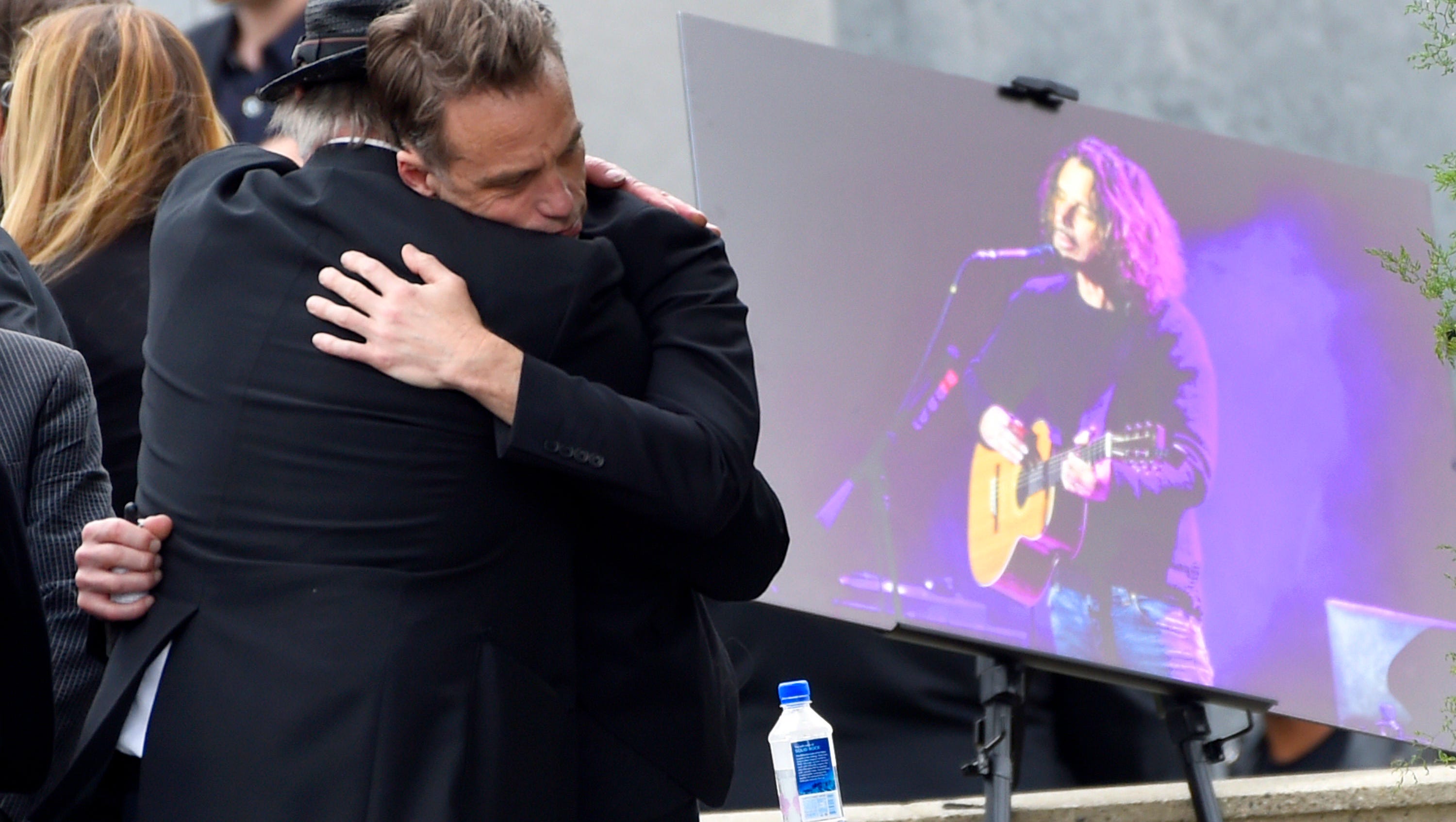 Matt Cameron, of Soundgarden, right, hugs a guest at a funeral for Chris Cornell, pictured right, at the Hollywood Forever Cemetery.