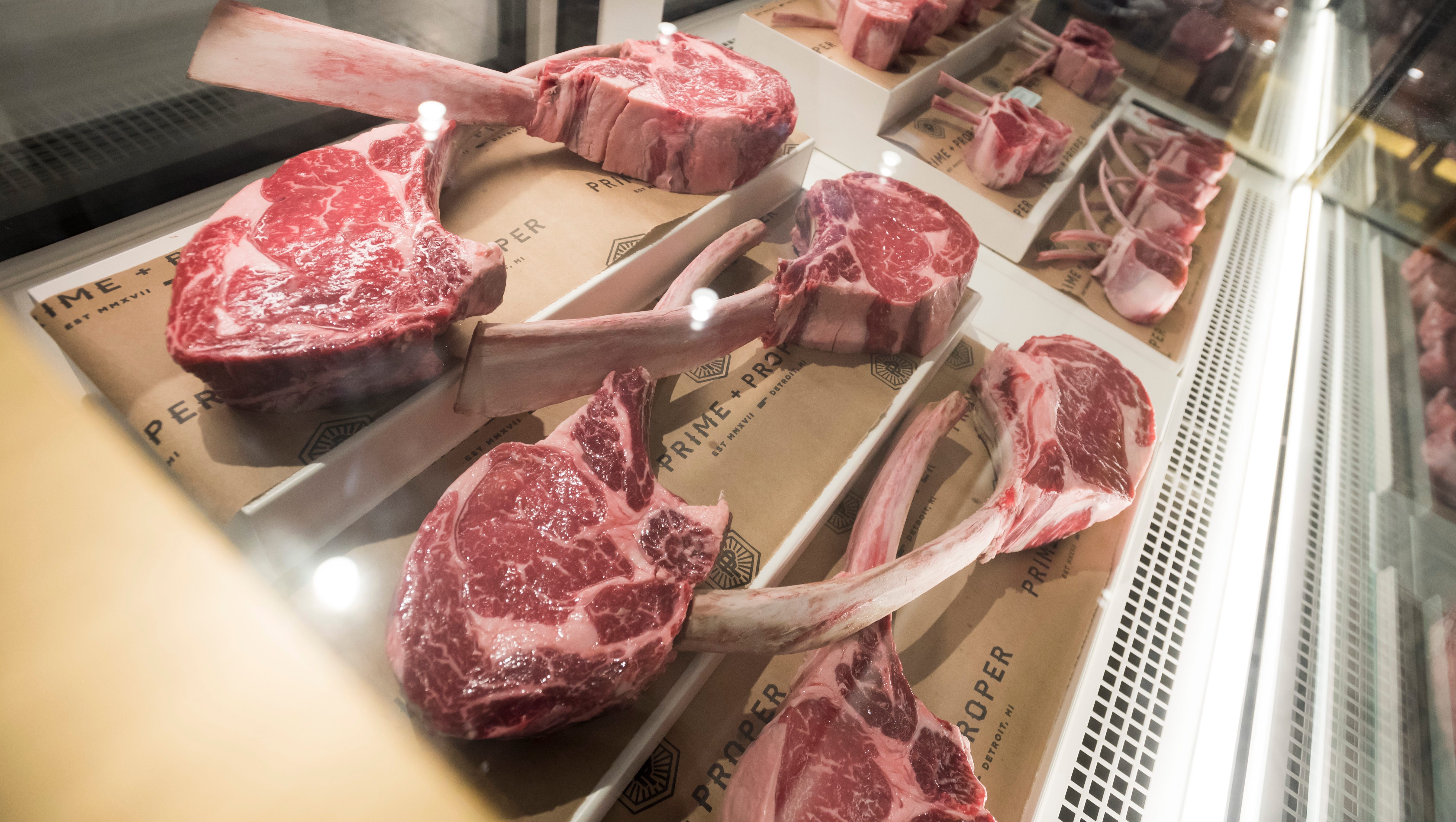 Tomahawk rib eye steaks inside the butcher display case.