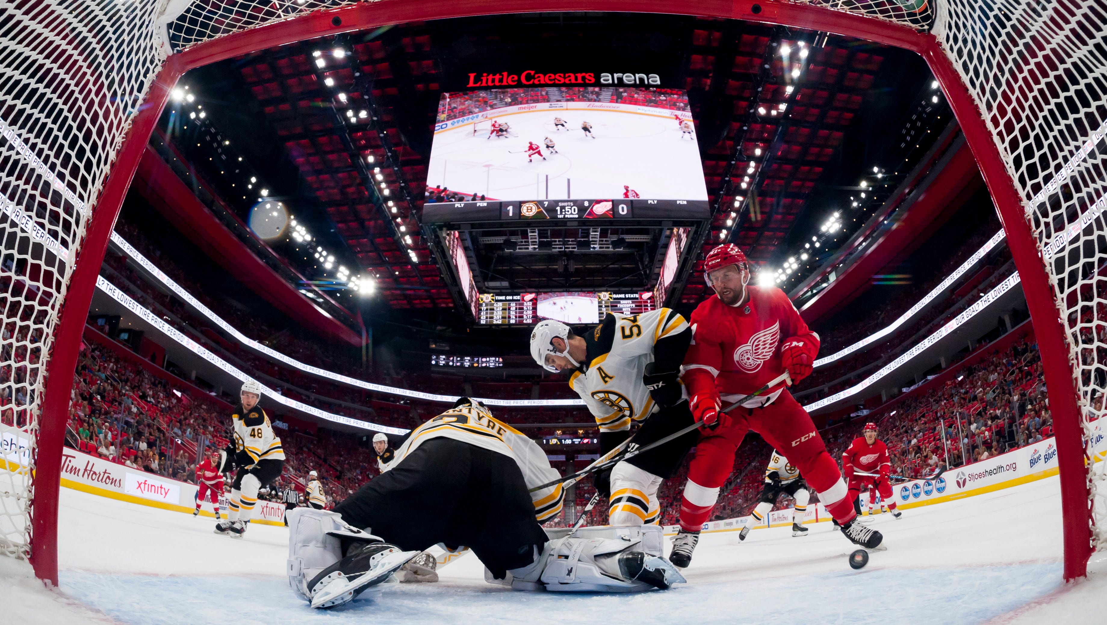 Detroit right wing Luke Glendening tries to get the puck past Boston goalie Zane McIntyre and Adam McQuaid in the first period at Little Caesars Arena, in Detroit, September 23, 2017.