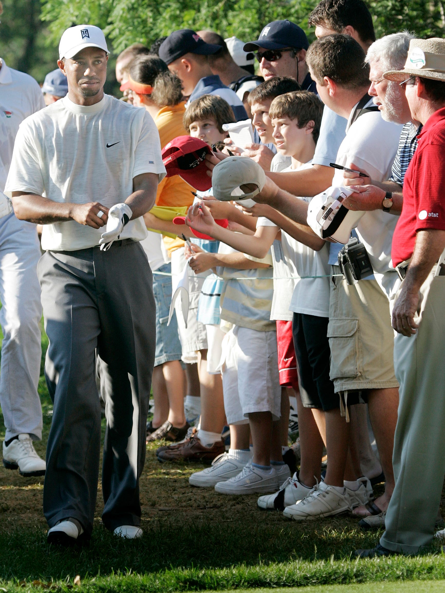 Tiger Woods walks through the gauntlet of autograph-seekers at the Buick Open pro-am in 2006.