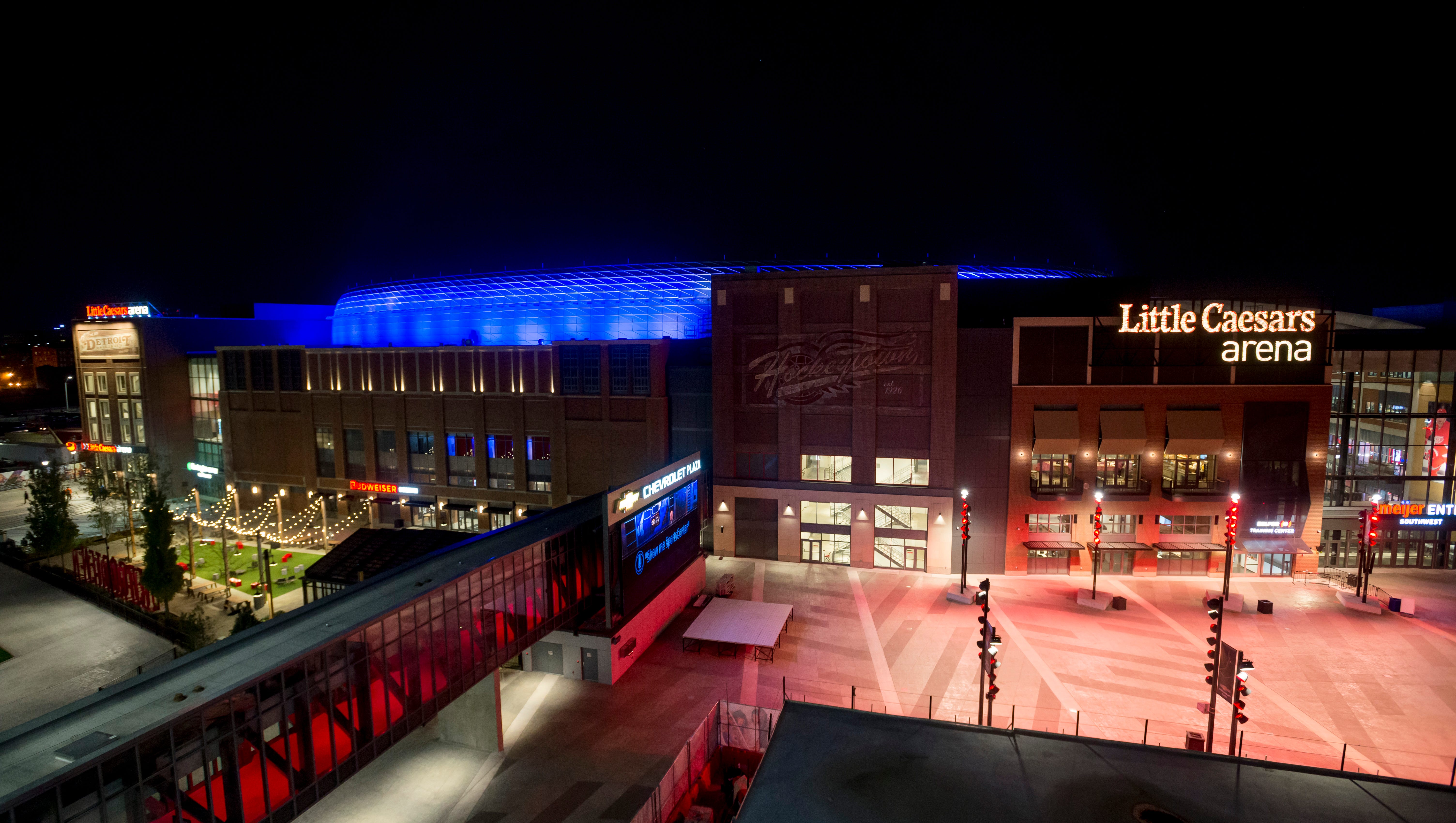Little Caesars Arena is lit up at night after a recent preseason hockey game.