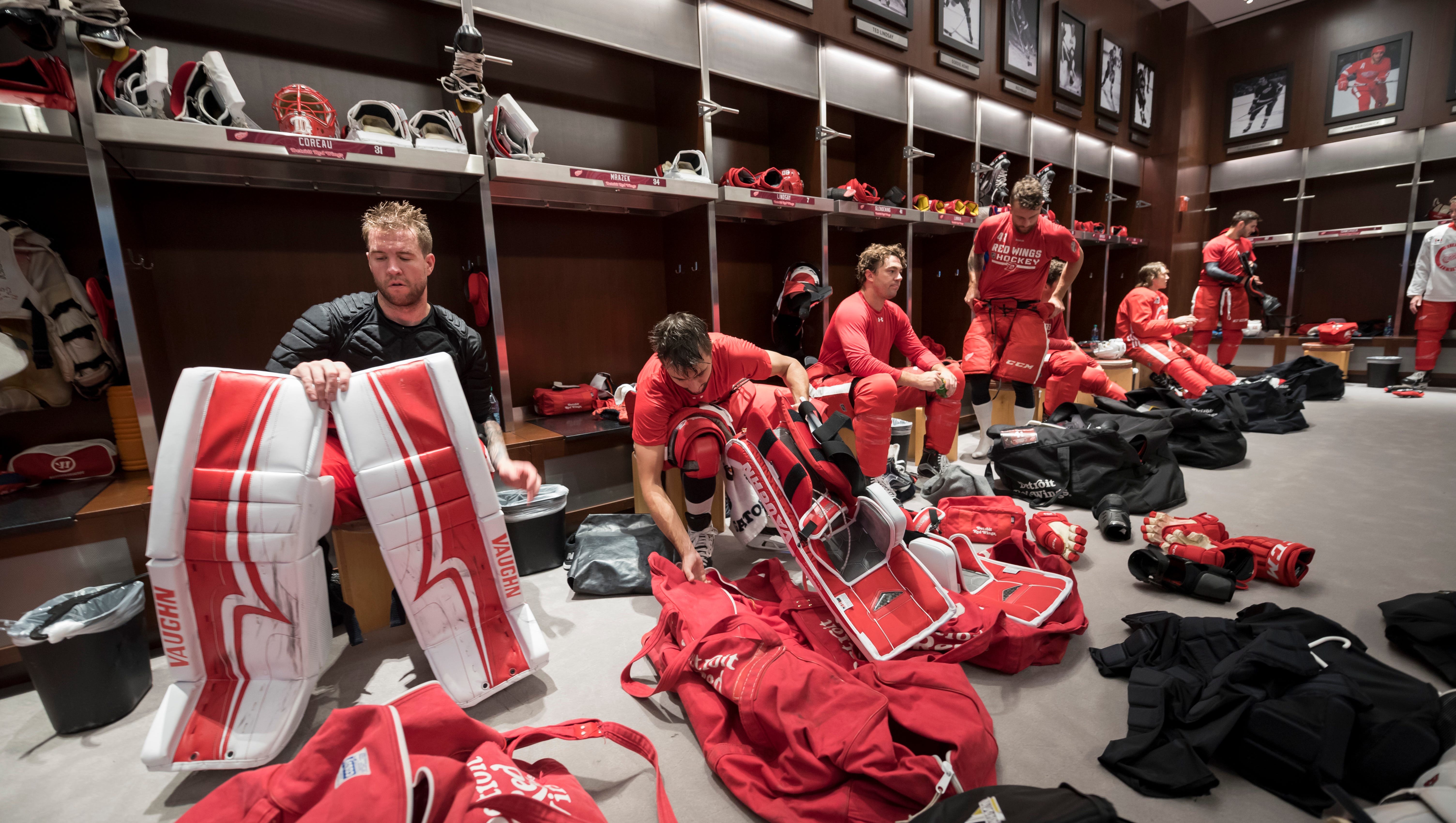 Red Wings players take off their uniforms in the locker room after practice.