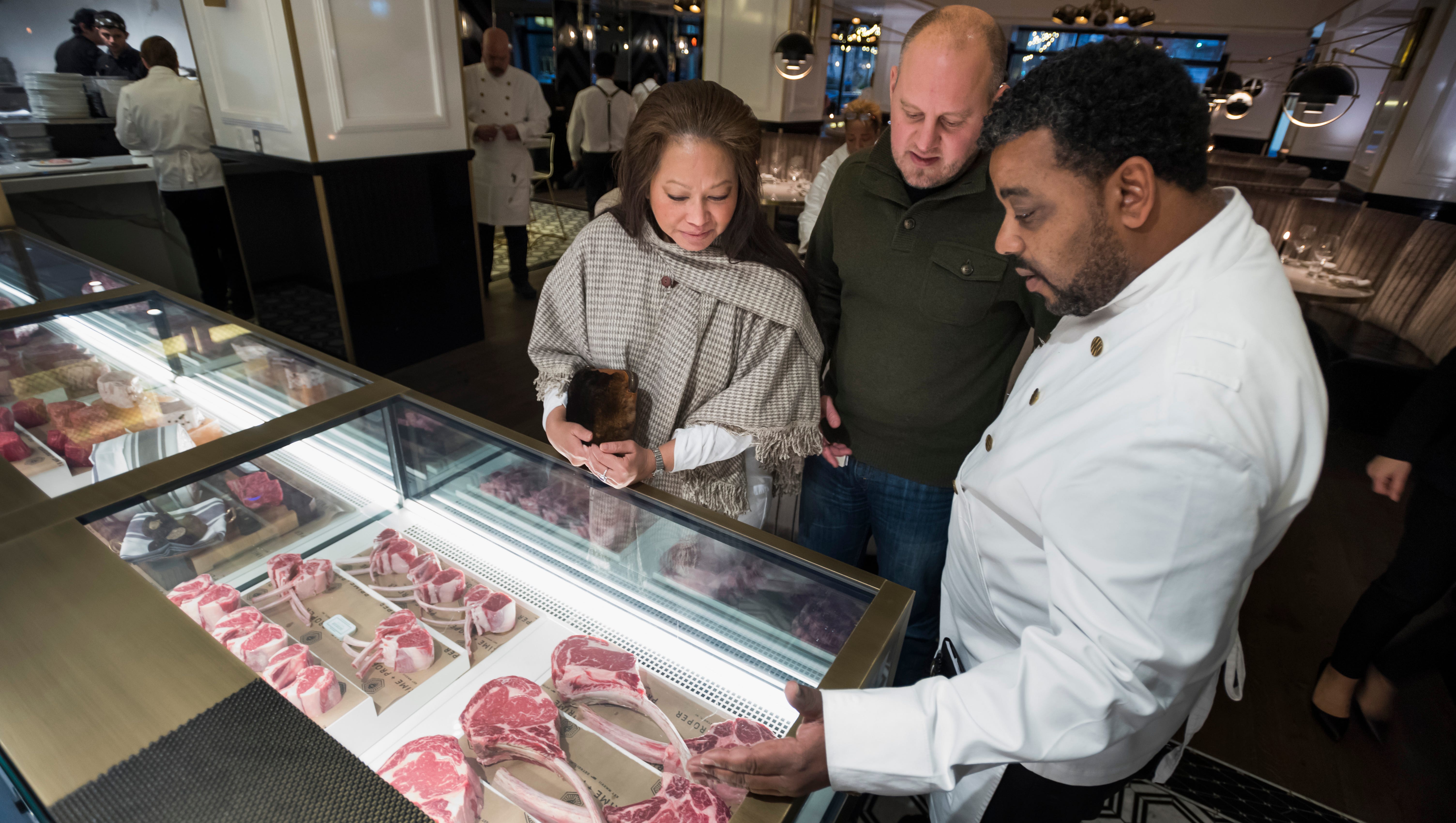 (From left) Paulina Aberle, and her husband, Scott, of Detroit, are shown the options inside the butcher display case by server Kenny Dias.