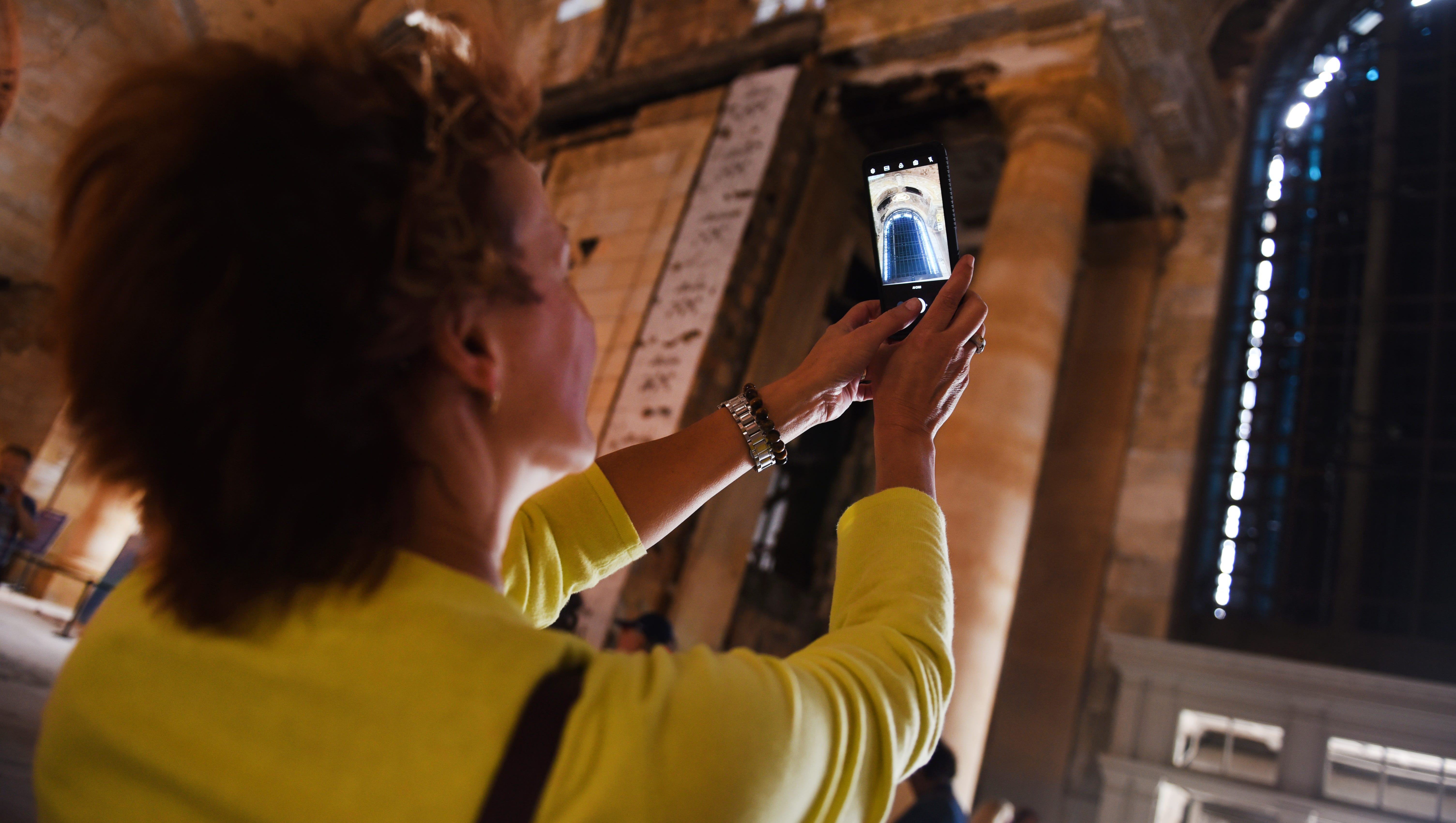 Jackie Lovejoy, president of the Dearborn chamber of commerce, uses her iPhone to photograph inside the Michigan Central Train Depot during Friday's open house.