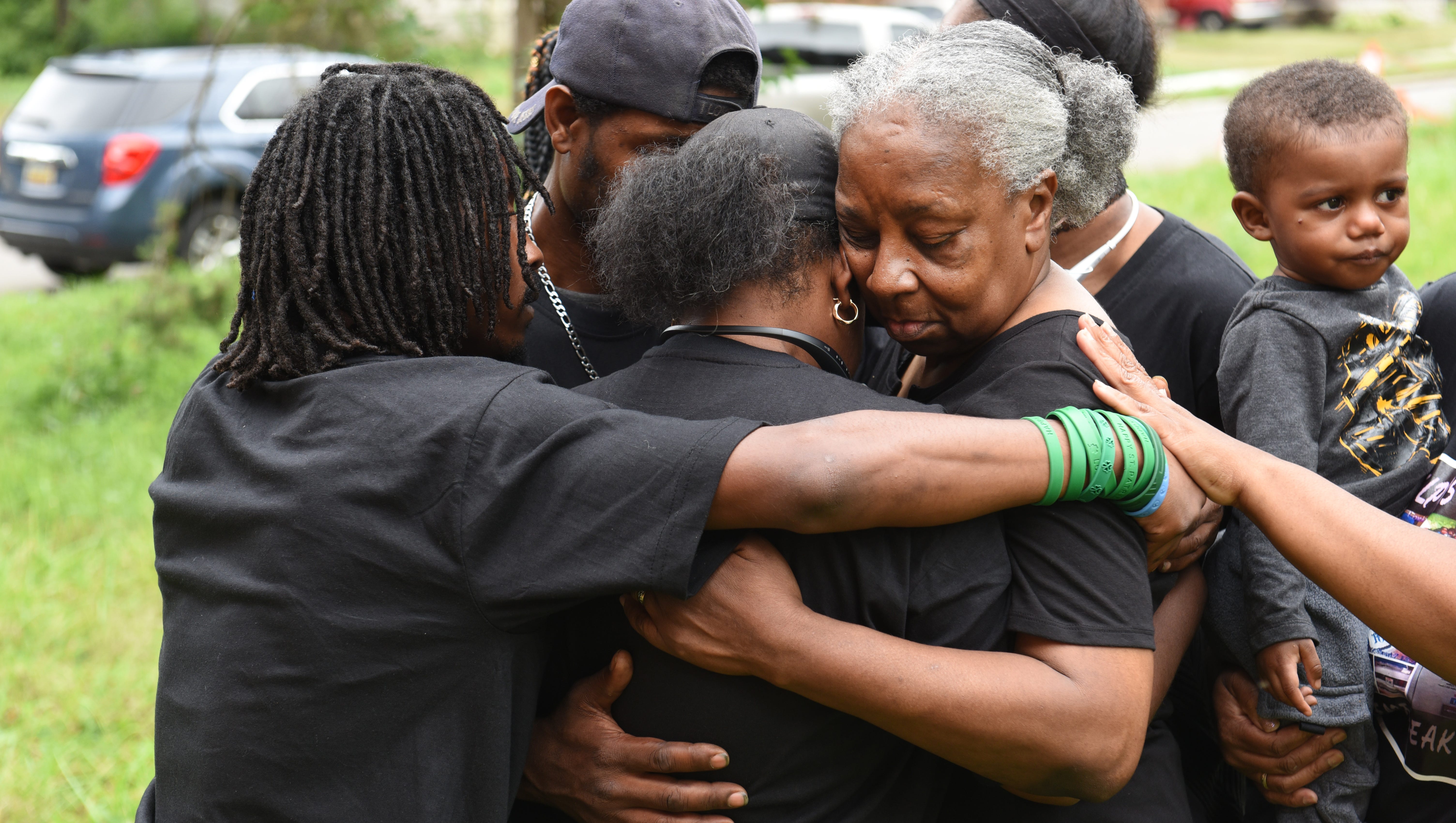 Aufelia Palmer (center), mother of Antonio Walker, gets a hug from her mother Loretta Taylor (right), moments after a  balloon release in remembrance of Antonio Walker, who was killed July 12, 2011.