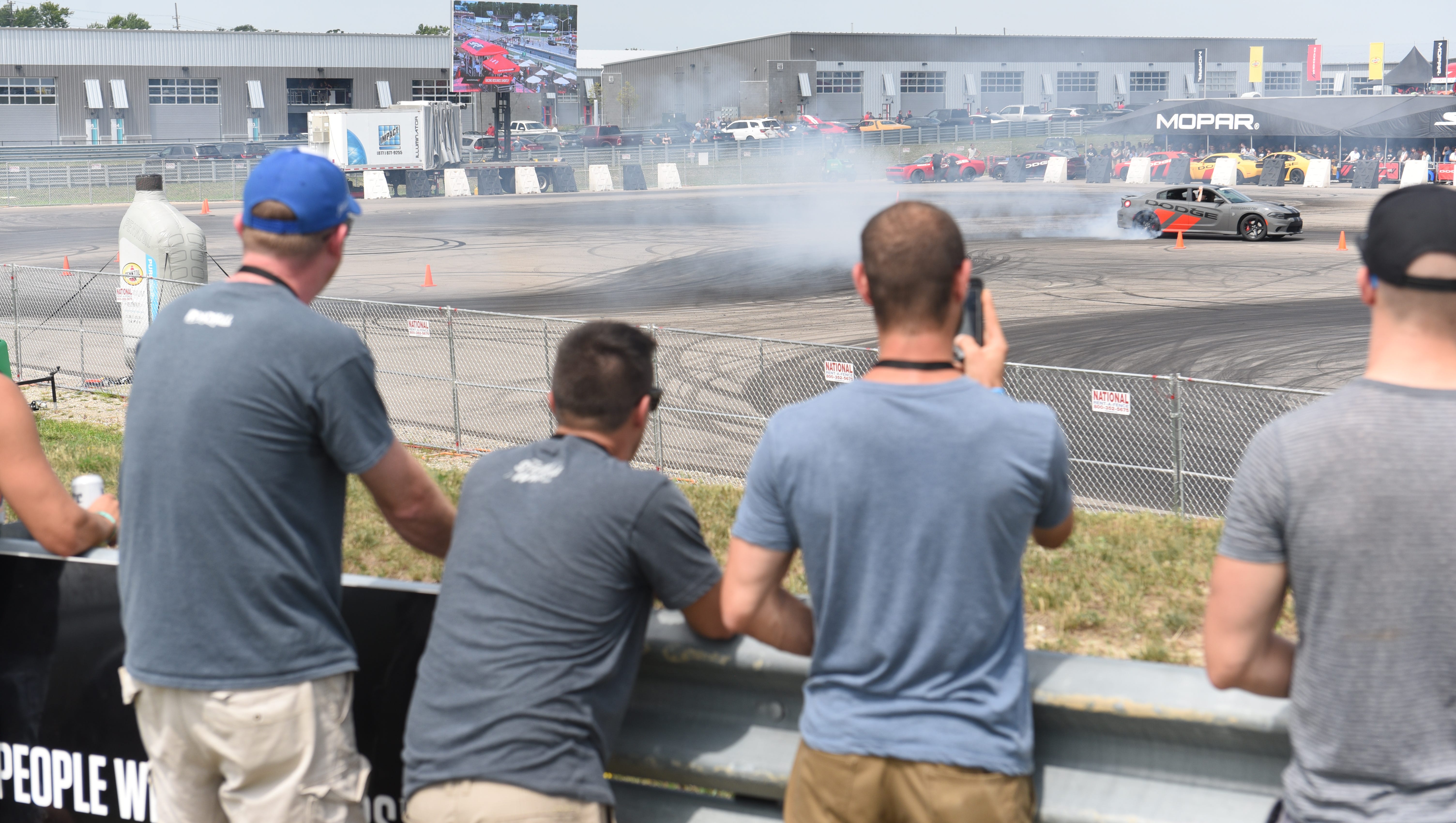 Fans watch a Dodge Charger Hellcat burnout at the Dodge drift rides demonstration .