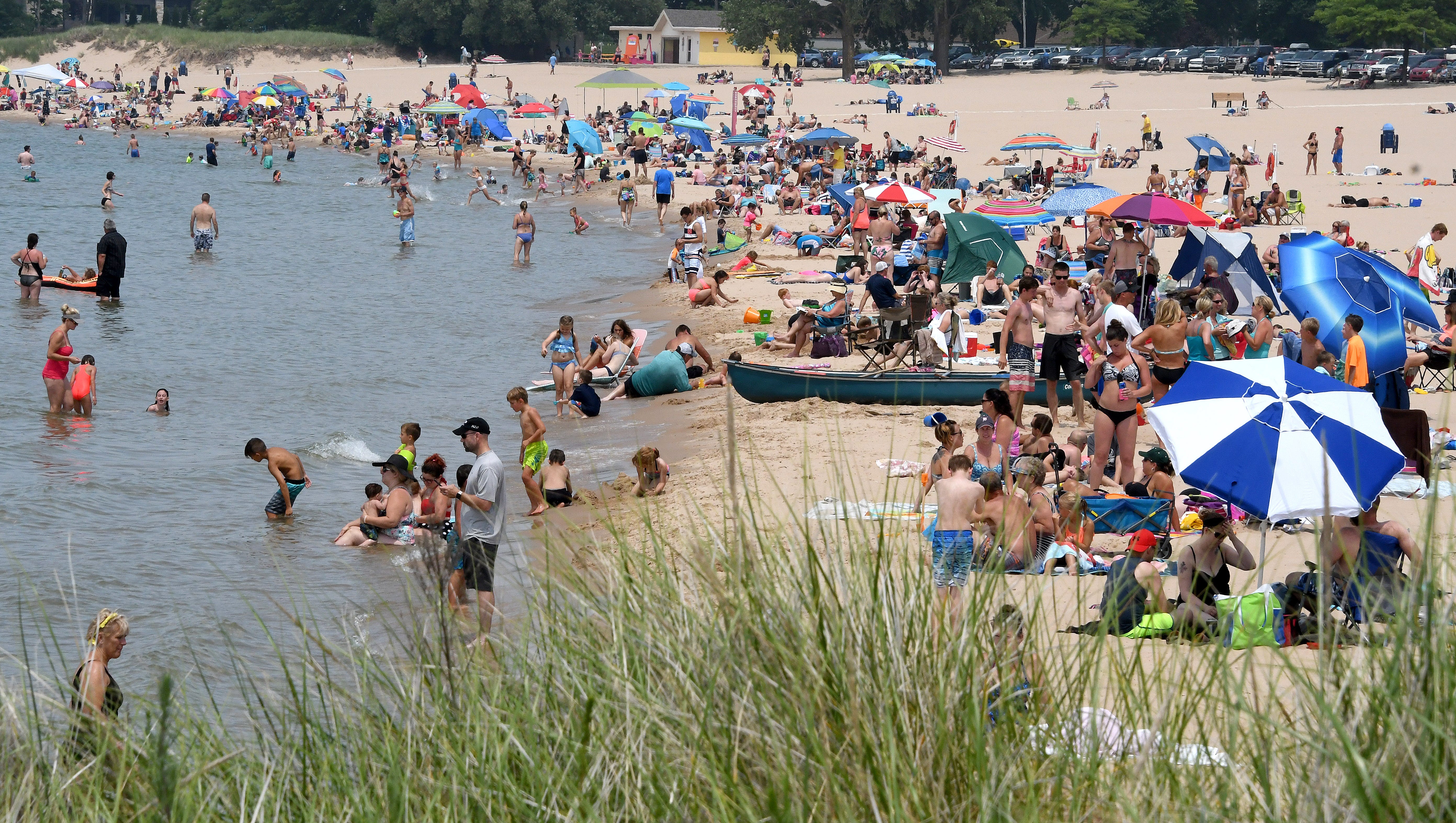 Swimmers and sunbathers at enjoy at day at the beach on Lake Michigan at Ludington on Thursday, July 5, 2018.