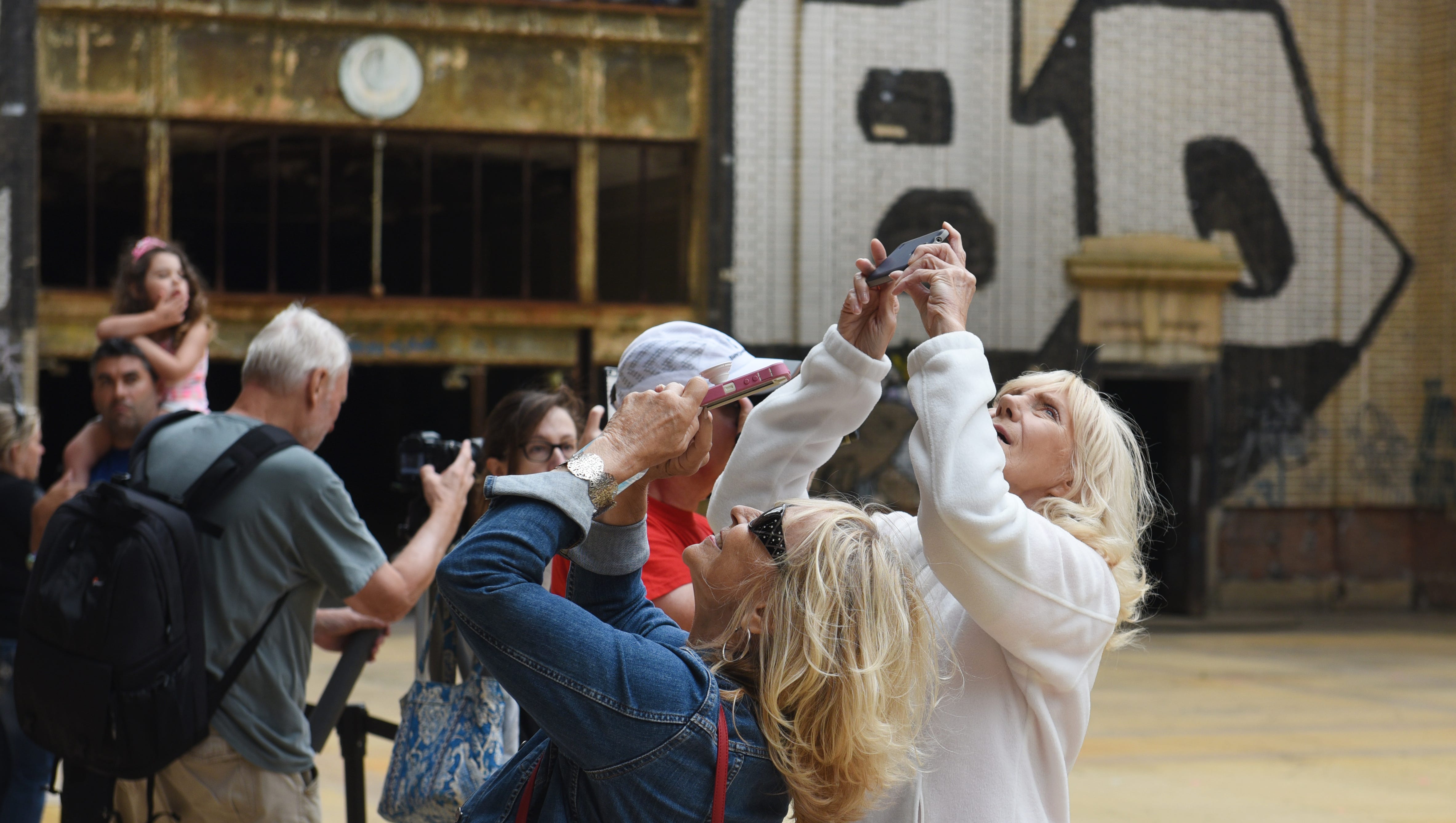 Terri Schroeder, left, and Barbara Vanerboget of Canton point their cameras skyward during an open house at the Michigan Central Train Depot.