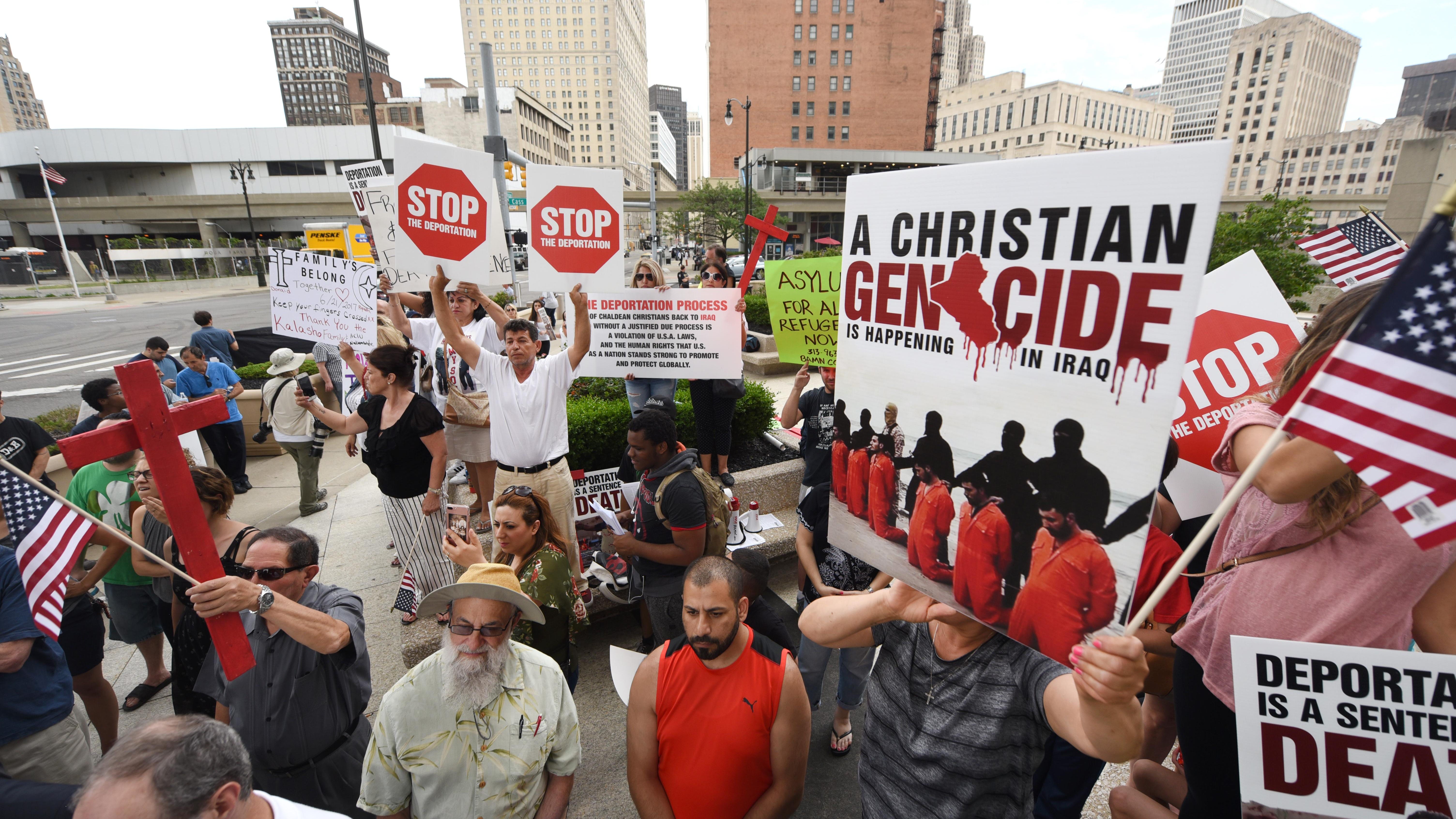 People carry signs protesting the deportation of Iraqi-American immigrants as members of the Chaldean community rallied at the McNamara Federal building in Detroit in June 2017.