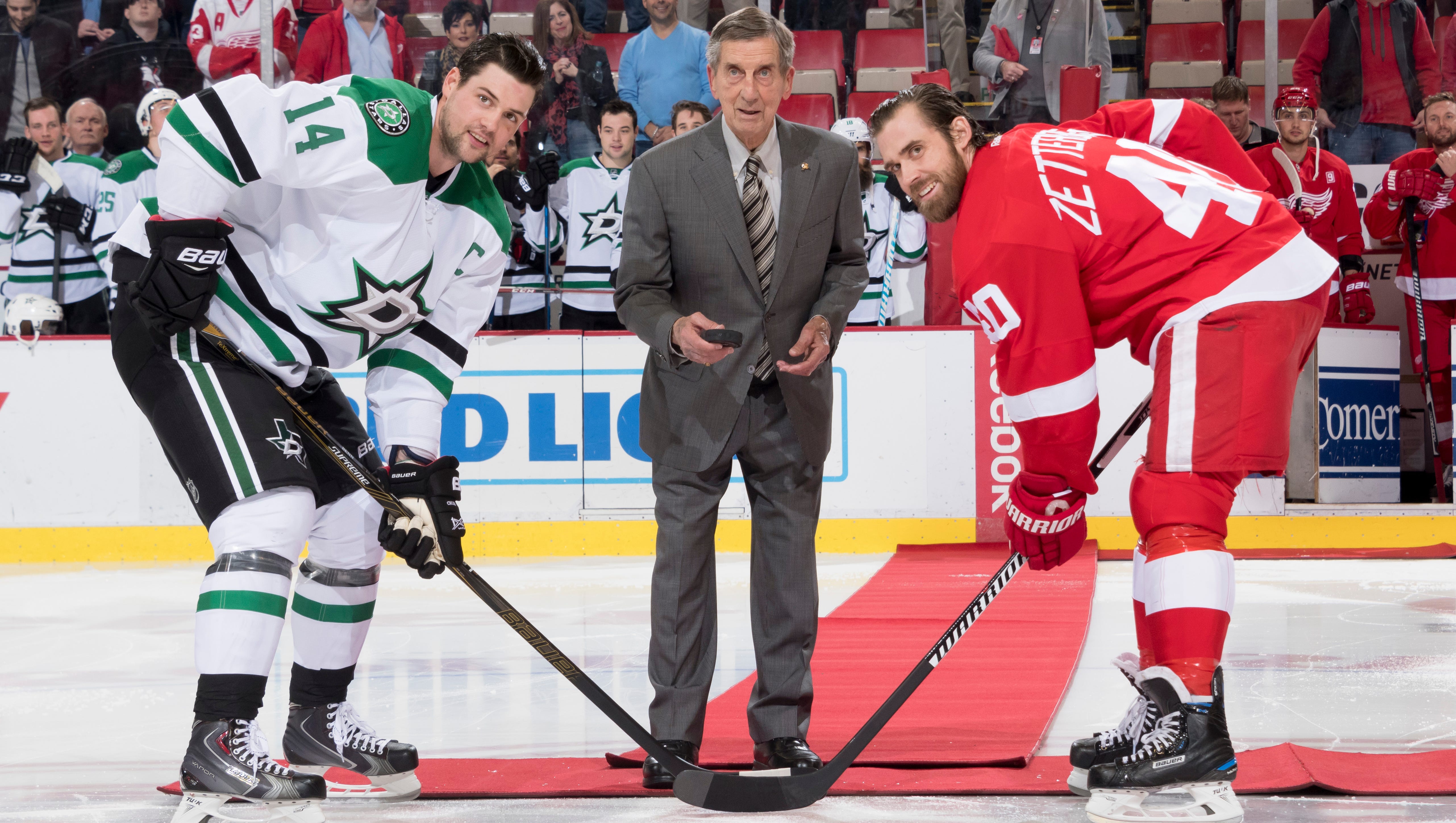 Red Wing Hall of Famer Ted Lindsay performs a ceremonial puck drop with Dallas left wing Jamie Benn and Detroit left wing Henrik Zetterberg before the start of the game.