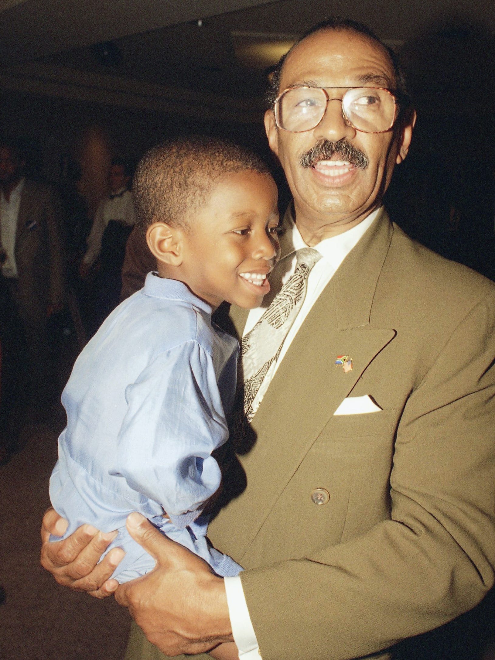 Conyers holds his son, John Conyers III, during his campaign primary victory party in 1994 in Detroit.