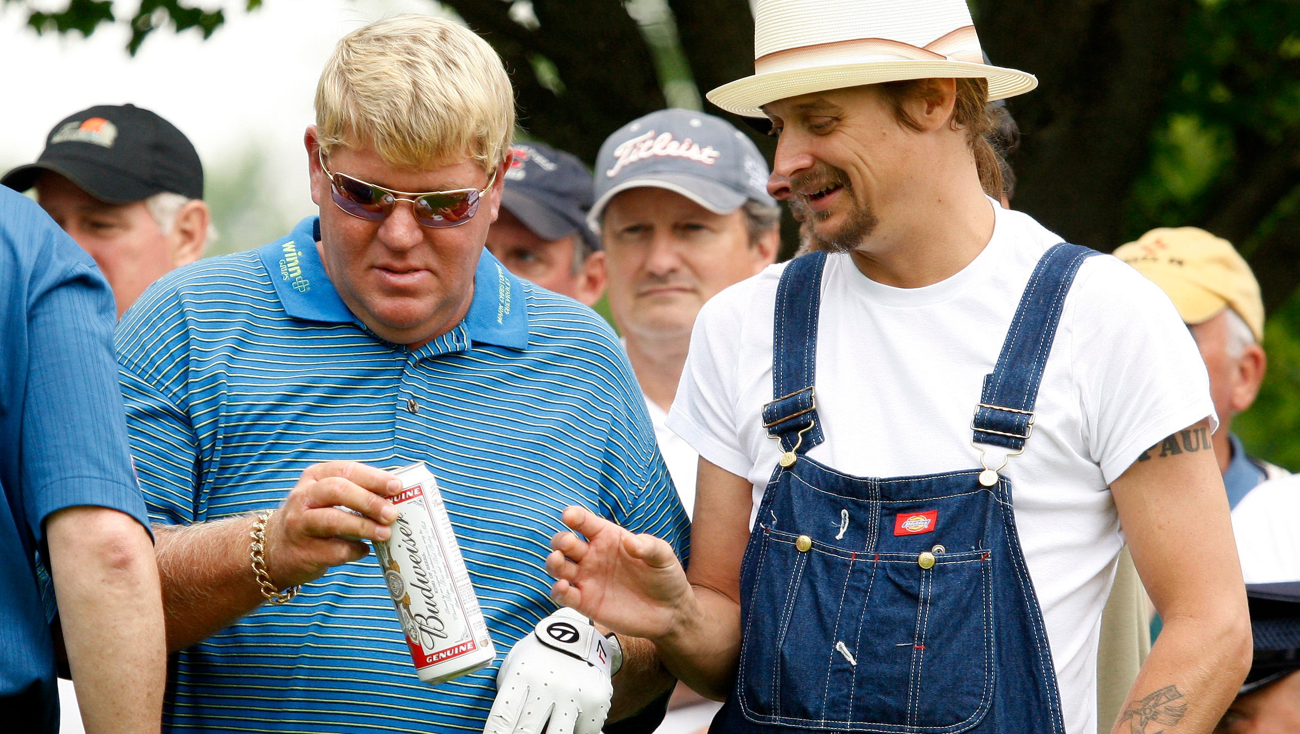Golfer John Daly takes a beer can from Kid Rock to use as a golf tee on the seventh tee during the 2008 Buick Open pro-am.