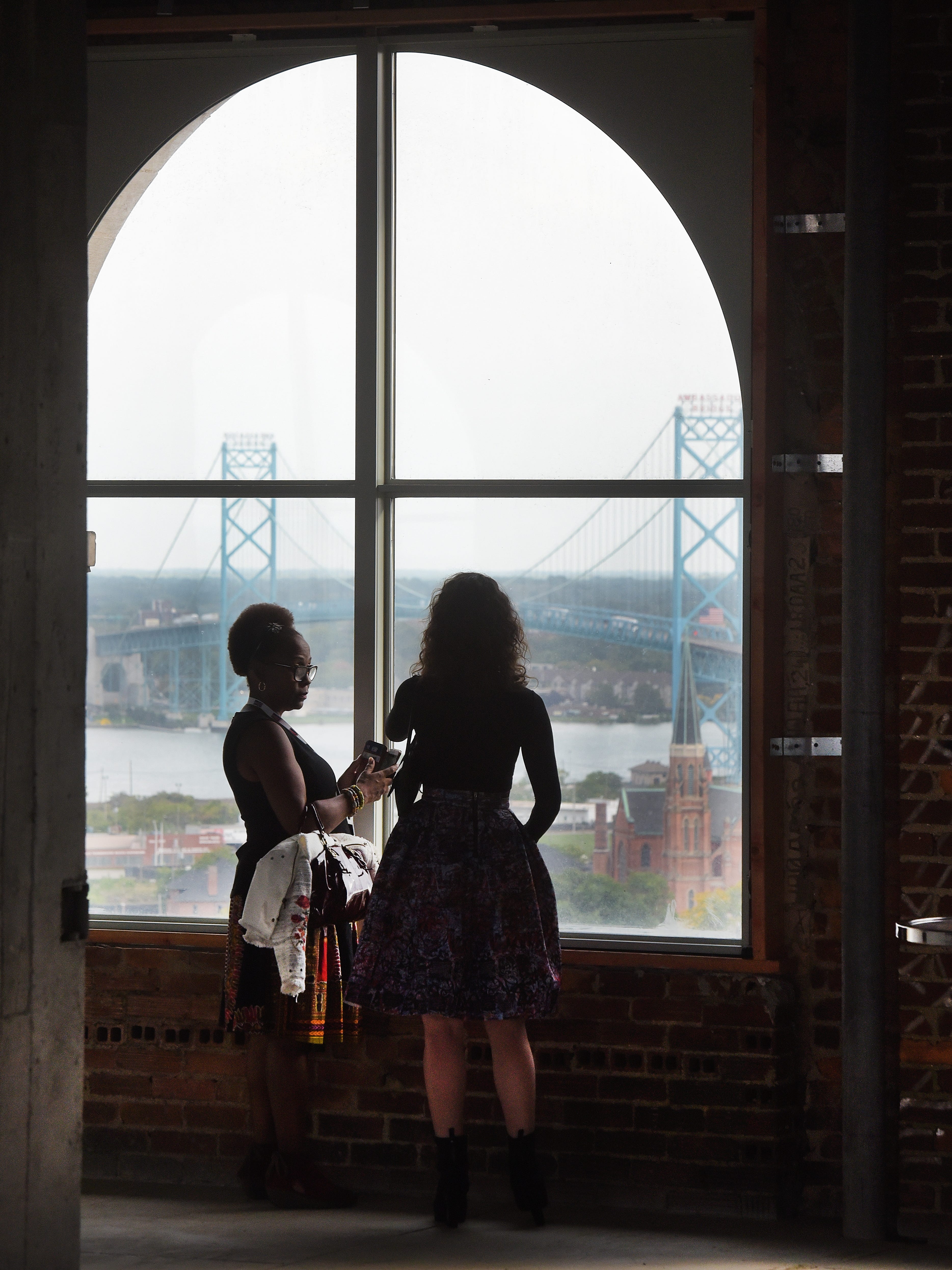 Wendy Hilliard and Ilyse Kaplan look over the view from the 13th floor of the Michigan Central Depot facing south, on September 13, 2017.
