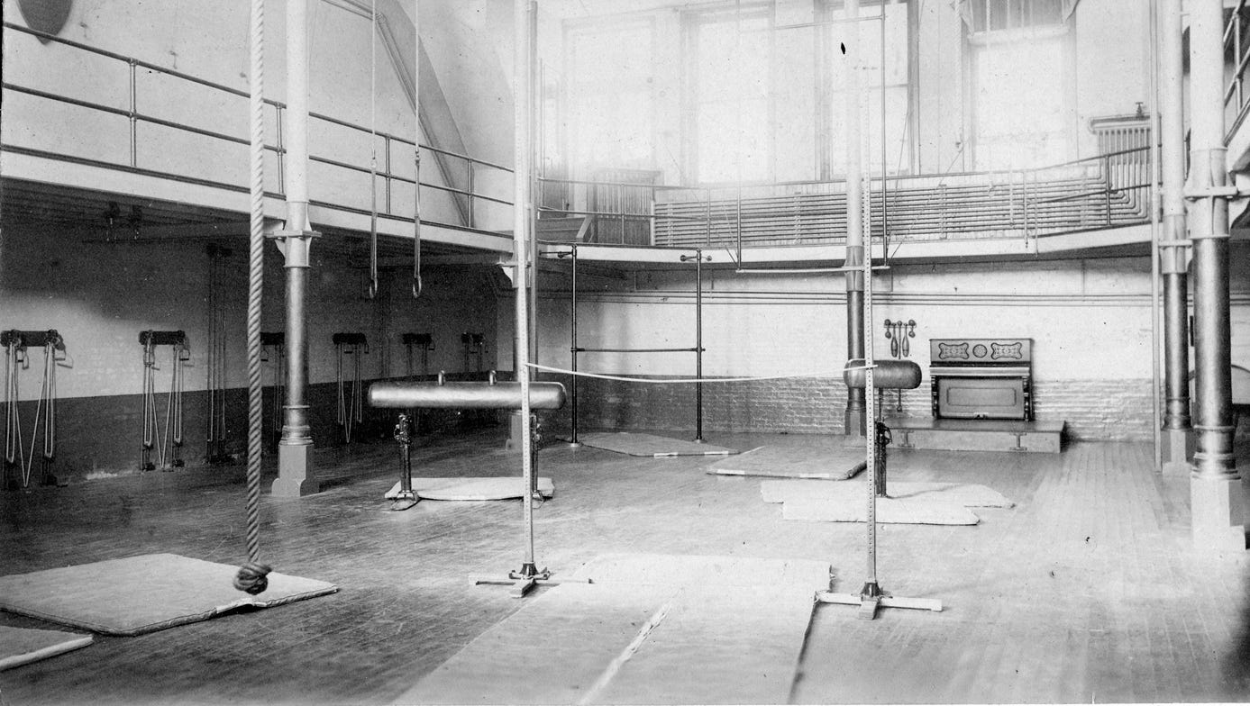 The YMCA gymnasium included gymnastics horses, climbing rope, rings, pulley weight systems, vaulting bars, Indian clubs and a piano. Electric lamps hung from the ceiling.