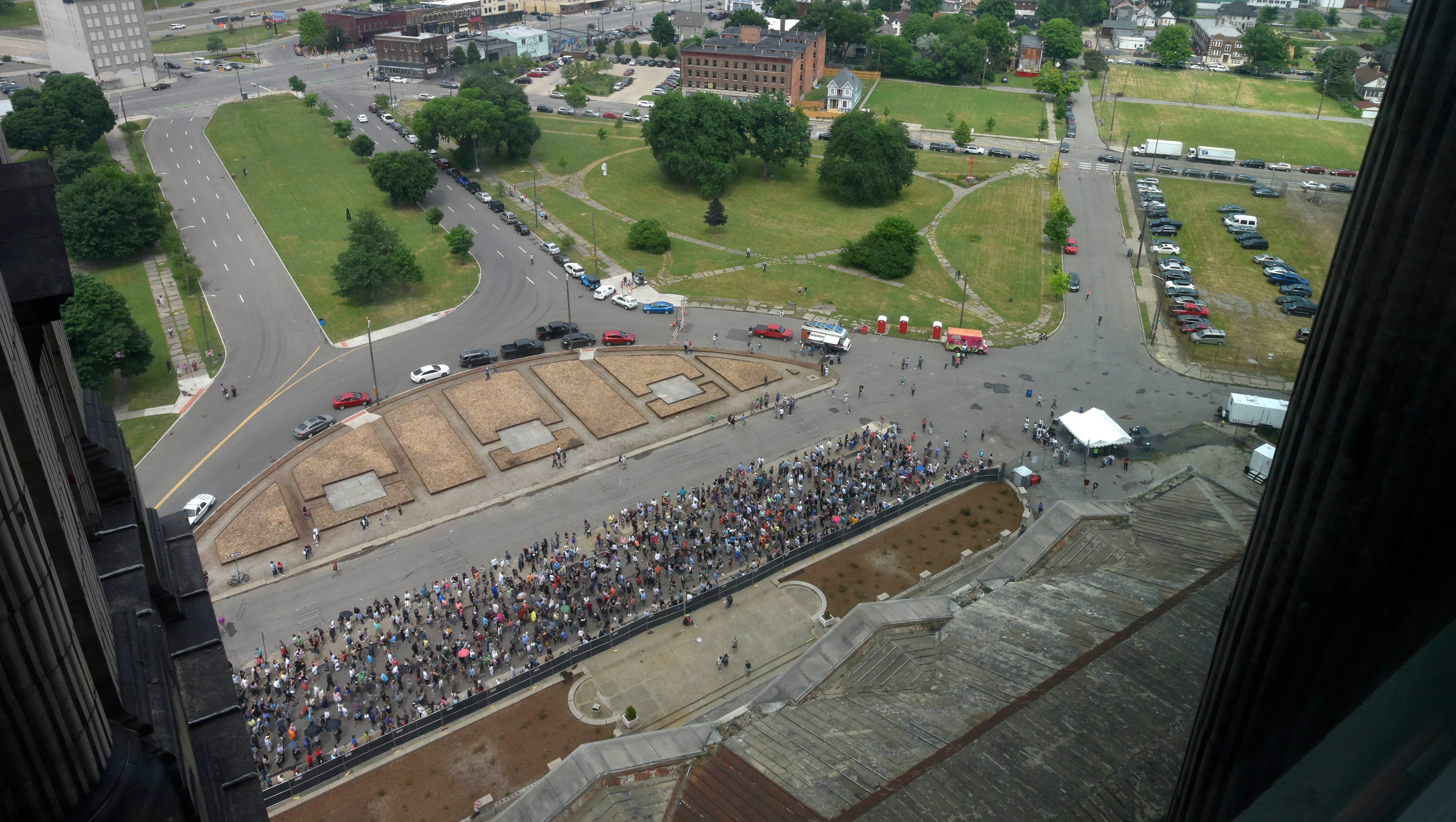 Throngs of people stand in line waiting to tour the Michigan Central Depot in Corktown.