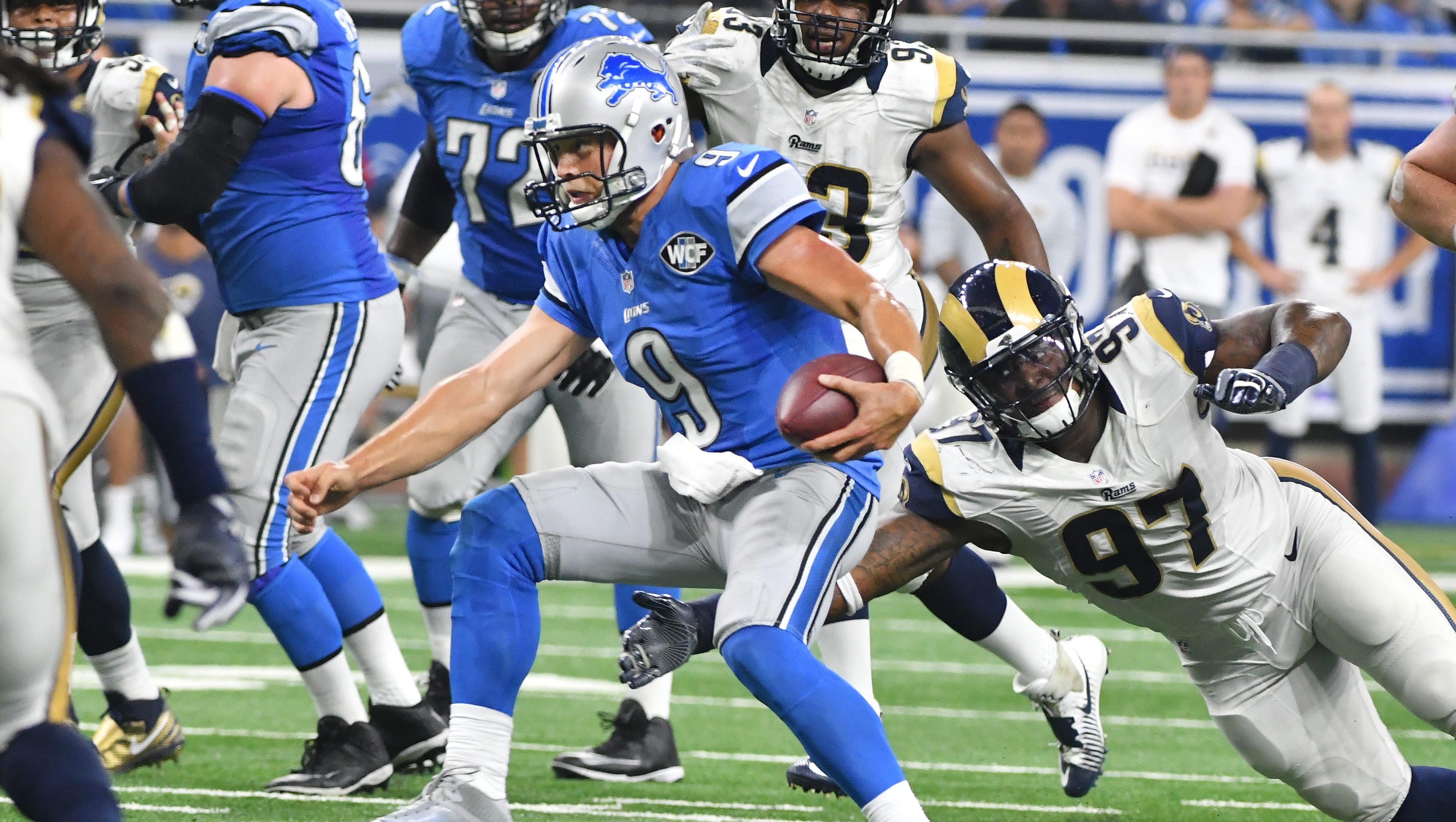 Lions quarterback Matthew Stafford scrambles away from Rams Eugene Sims for a first down late in the fourth quarter.