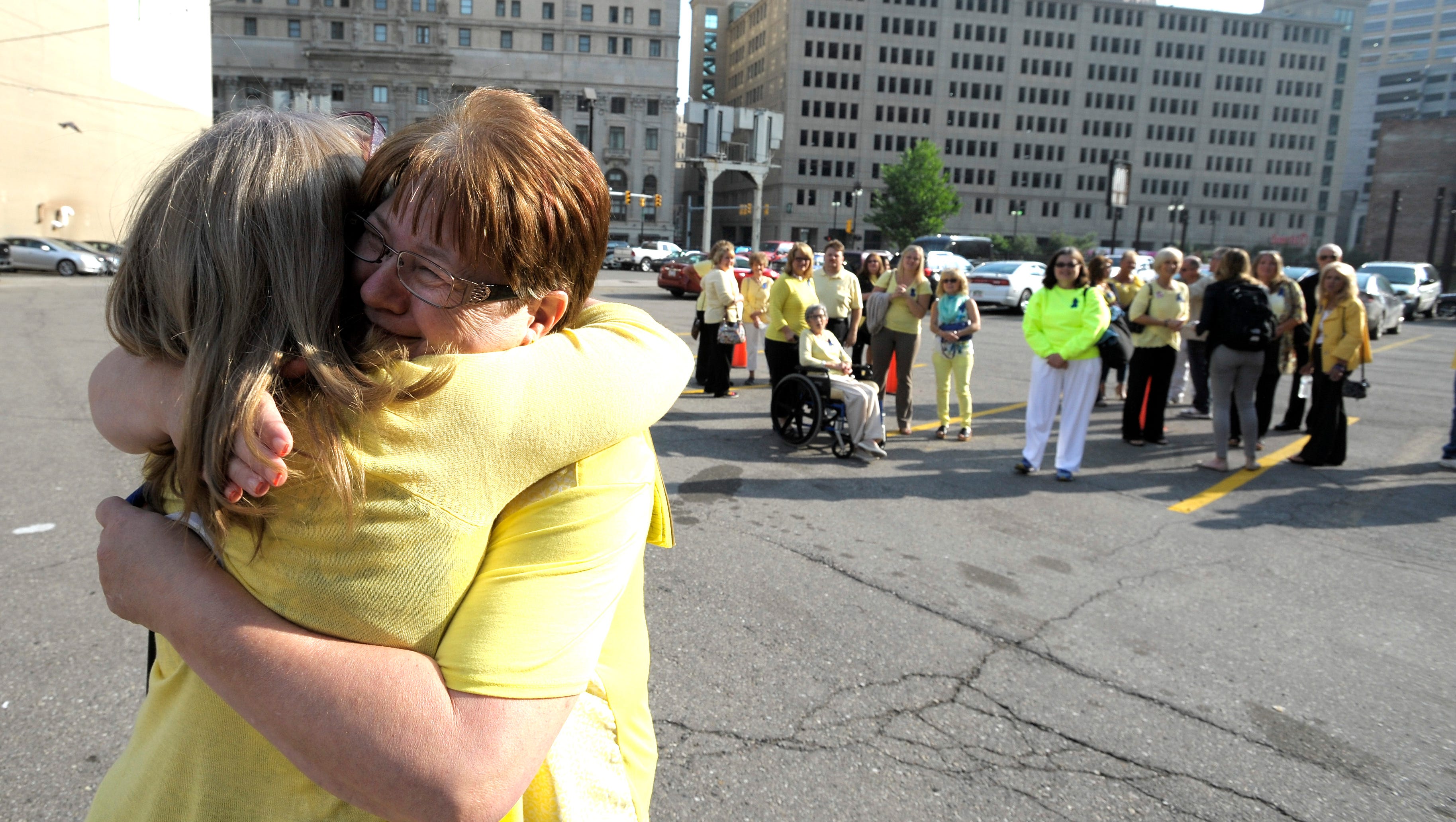 Donna Adams, left, 54, of Romeo, whose father-in-law, Rudy Adams, was a patient of Fata's and is still alive, hugs Geraldine Parkin, right, 54, of Davison, whose husband, Tim, was overtreated by Fata and is still alive.