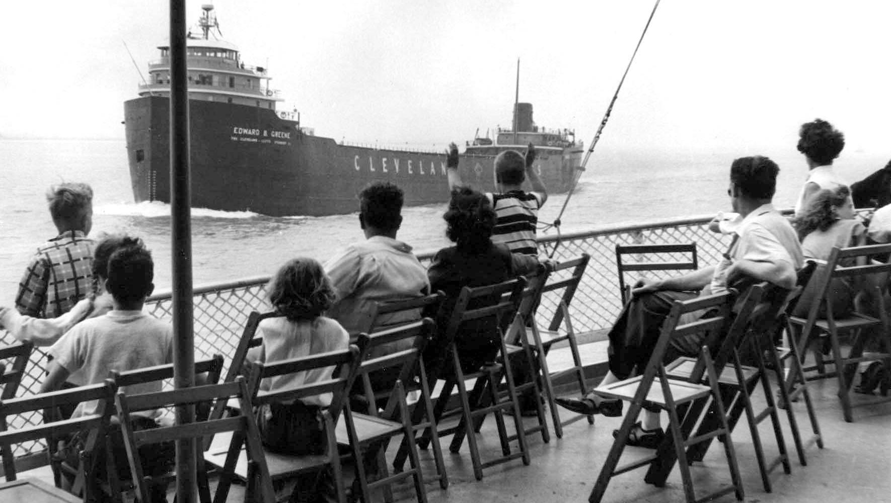 Passengers catch a cool breeze and a view of a  freighter from the Boblo boat.