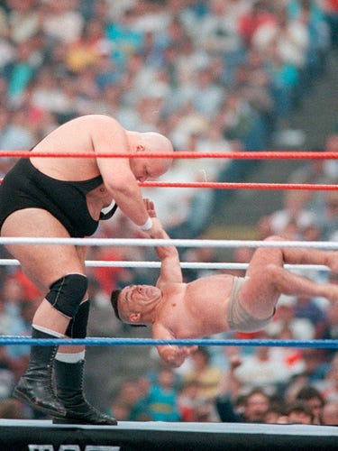 King Kong Bundy picks on someone, umm, not quite his own size in a six-man tag-team match.