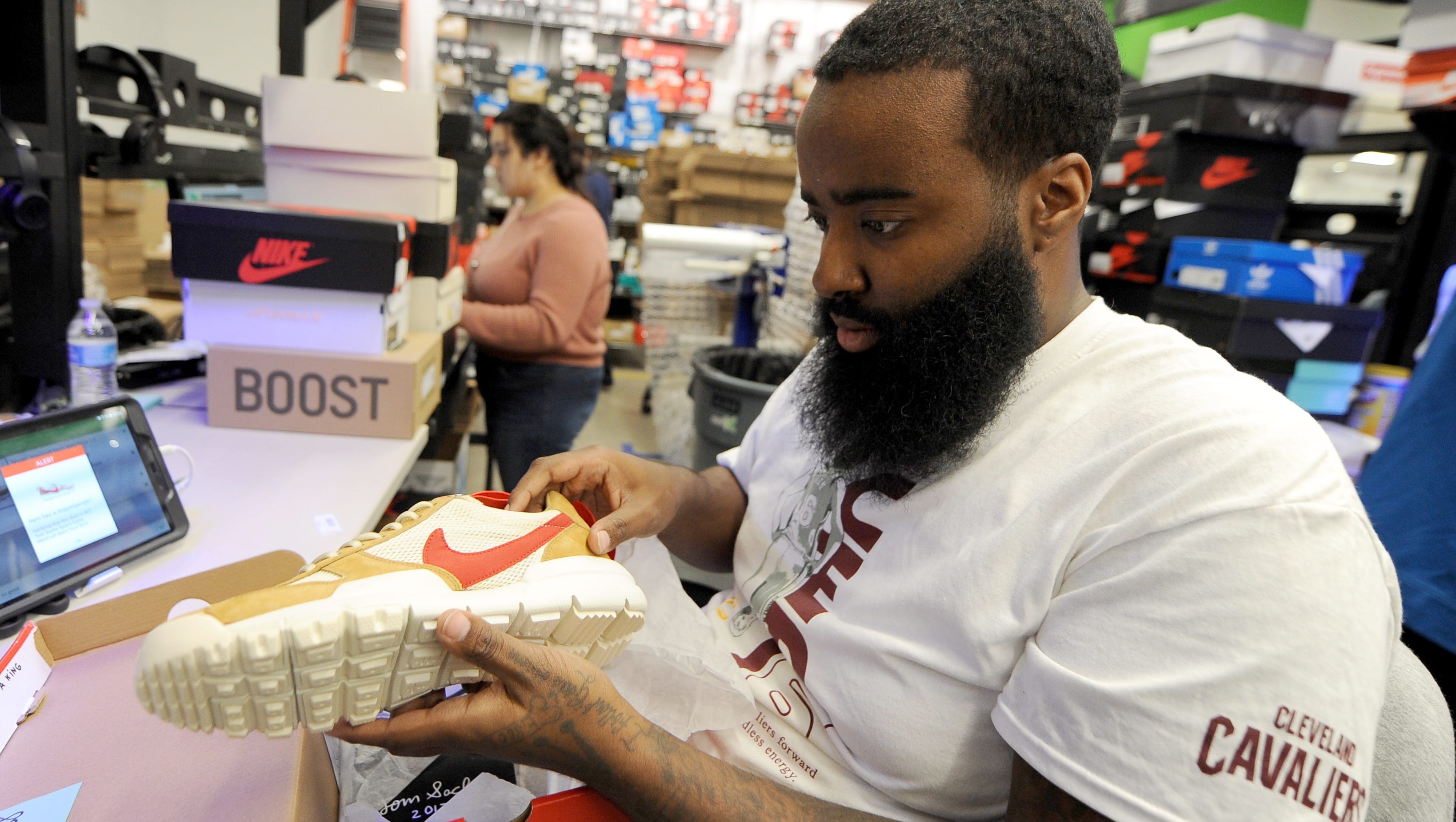 Aaron Fields, senior authenticator for StockX,  inspects a pair of Nike Mars Yard sneakers.