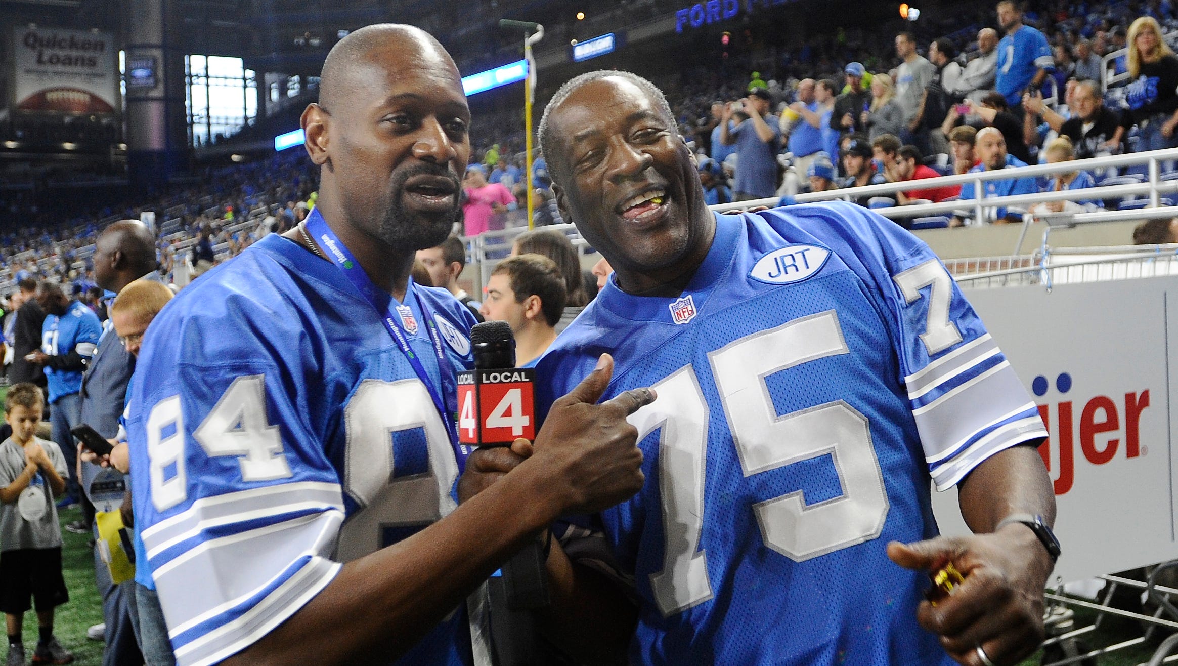 Members of the 1991 Detroit Lions Herman Moore and Lomas Brown work the sidelines before the Lions take on the Los Angeles Rams at Ford Field in Detroit on October 16, 2016.