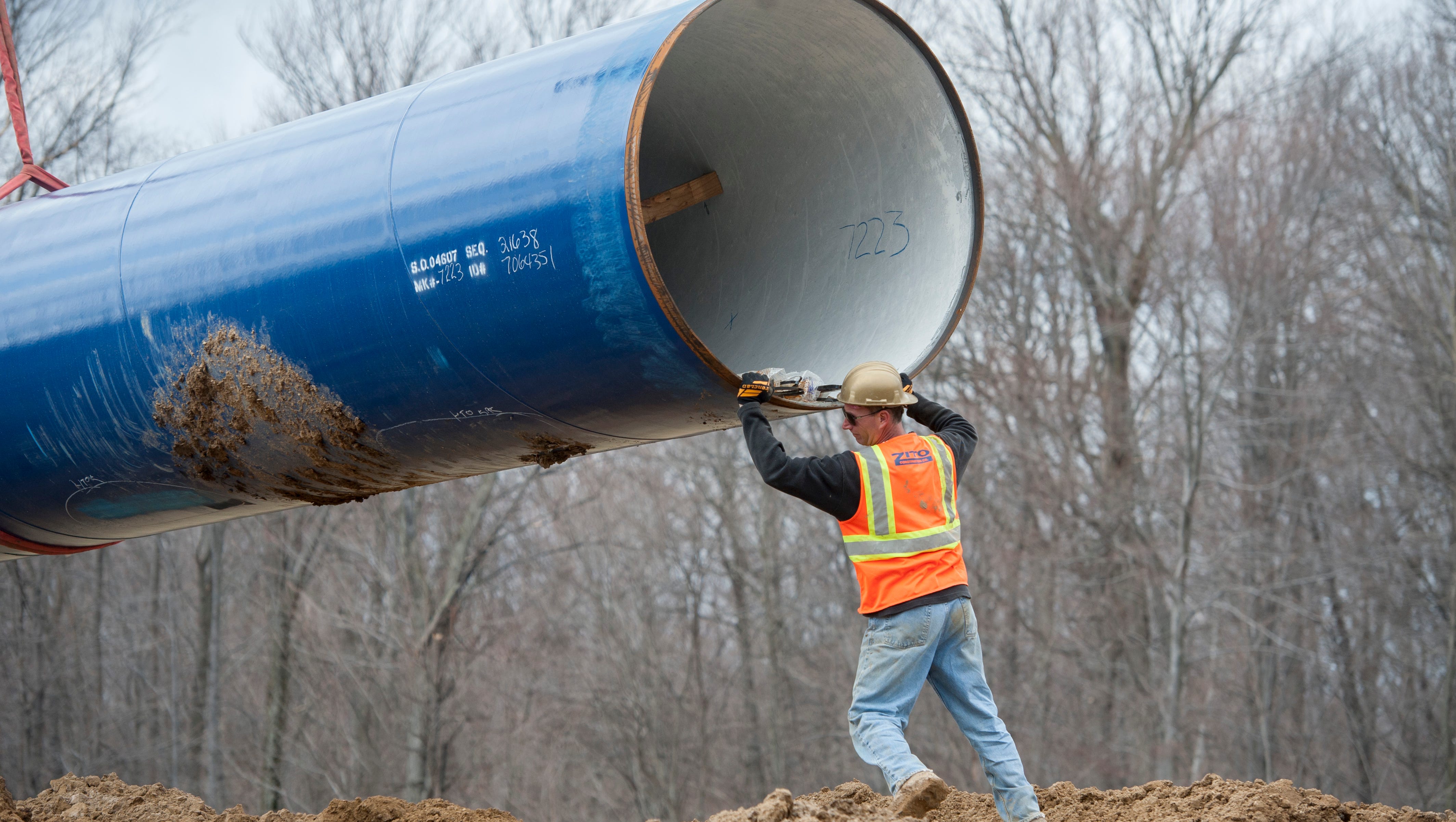 Laborers place a 50-foot section of the pipeline.