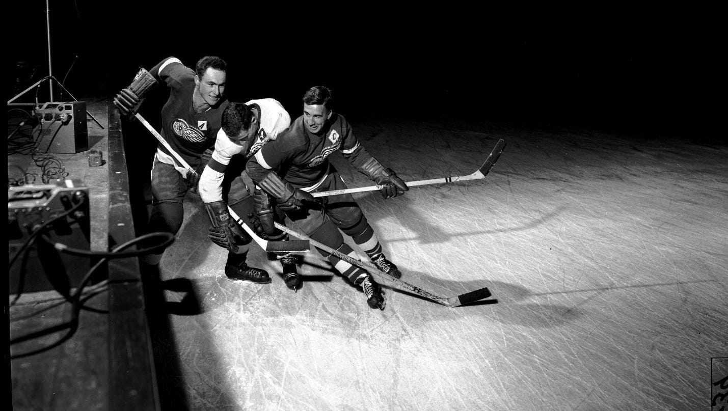 Red Kelly, left, and Ted Lindsay, right, battle for the puck at practice.
