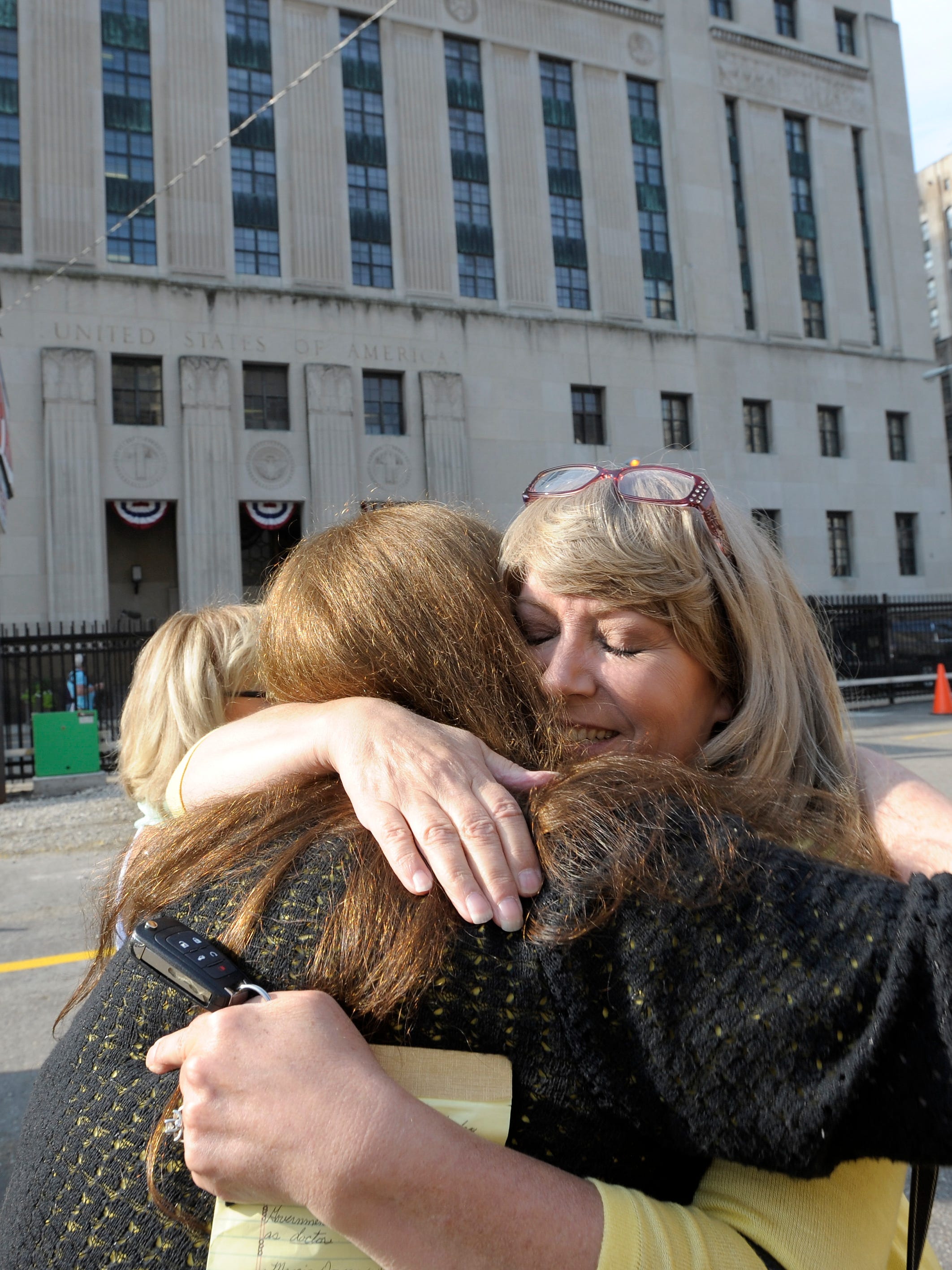 Donna Adams, right, 54, of Romeo, whose father-in-law, Rudy Adams, was a patient of Fata's and is still alive, hugs Karen Compton, left, 55, of Otter Lake, whose mother died of cancer.