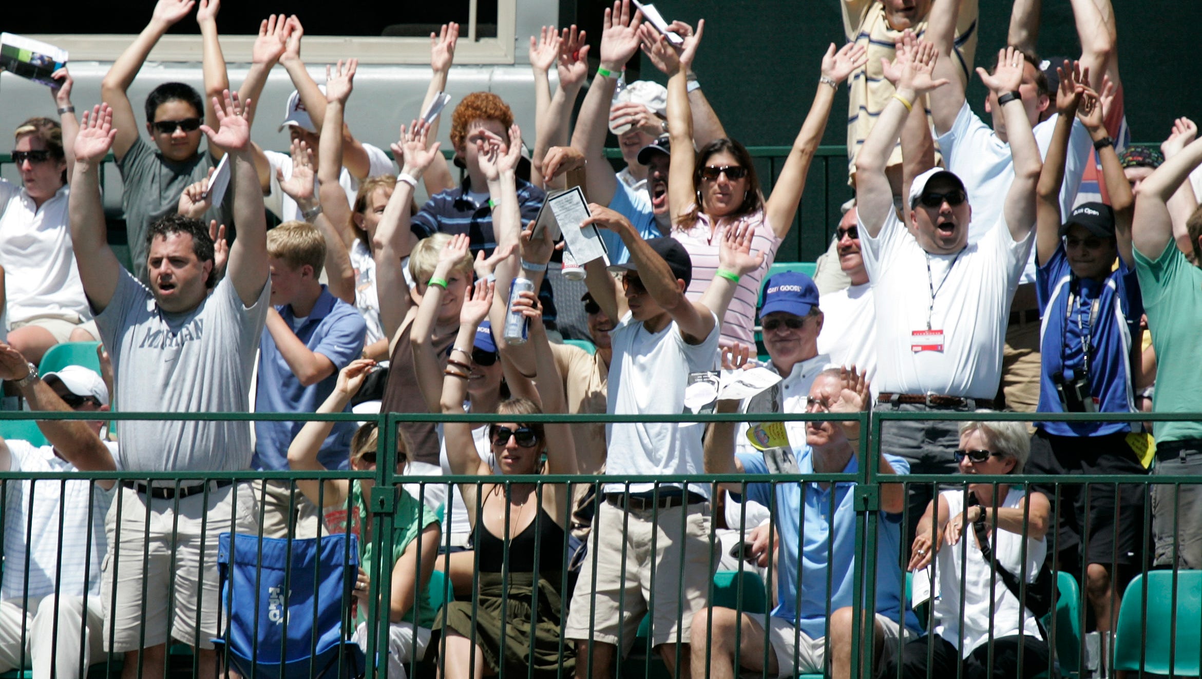 Fans surrounding the 17th green get the wave going during a break in the action during the 2008 Buick Open.