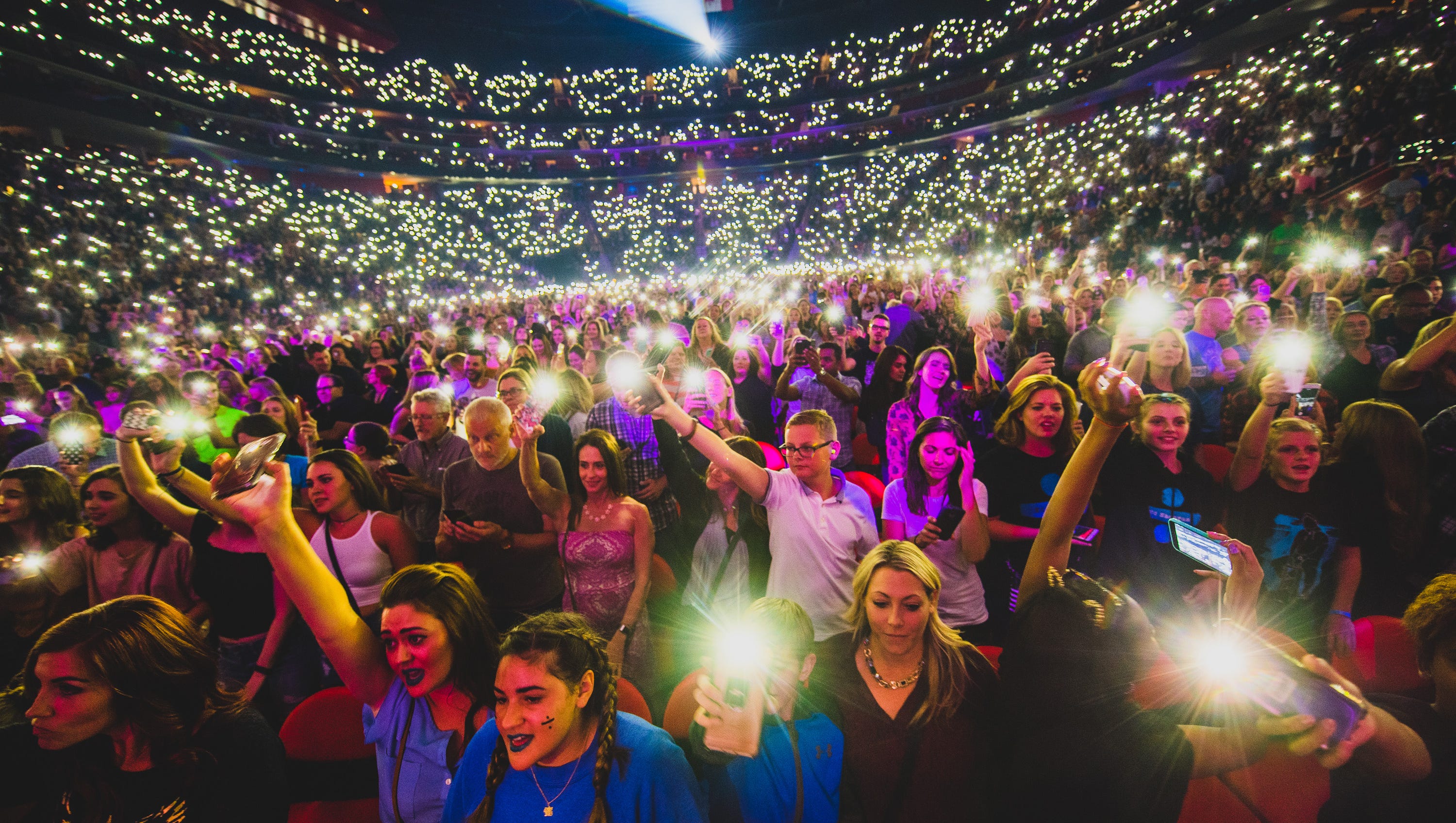 Fans light up their cellphone flash lights at a sold-out Ed Sheeran concert on September 27, 2017.