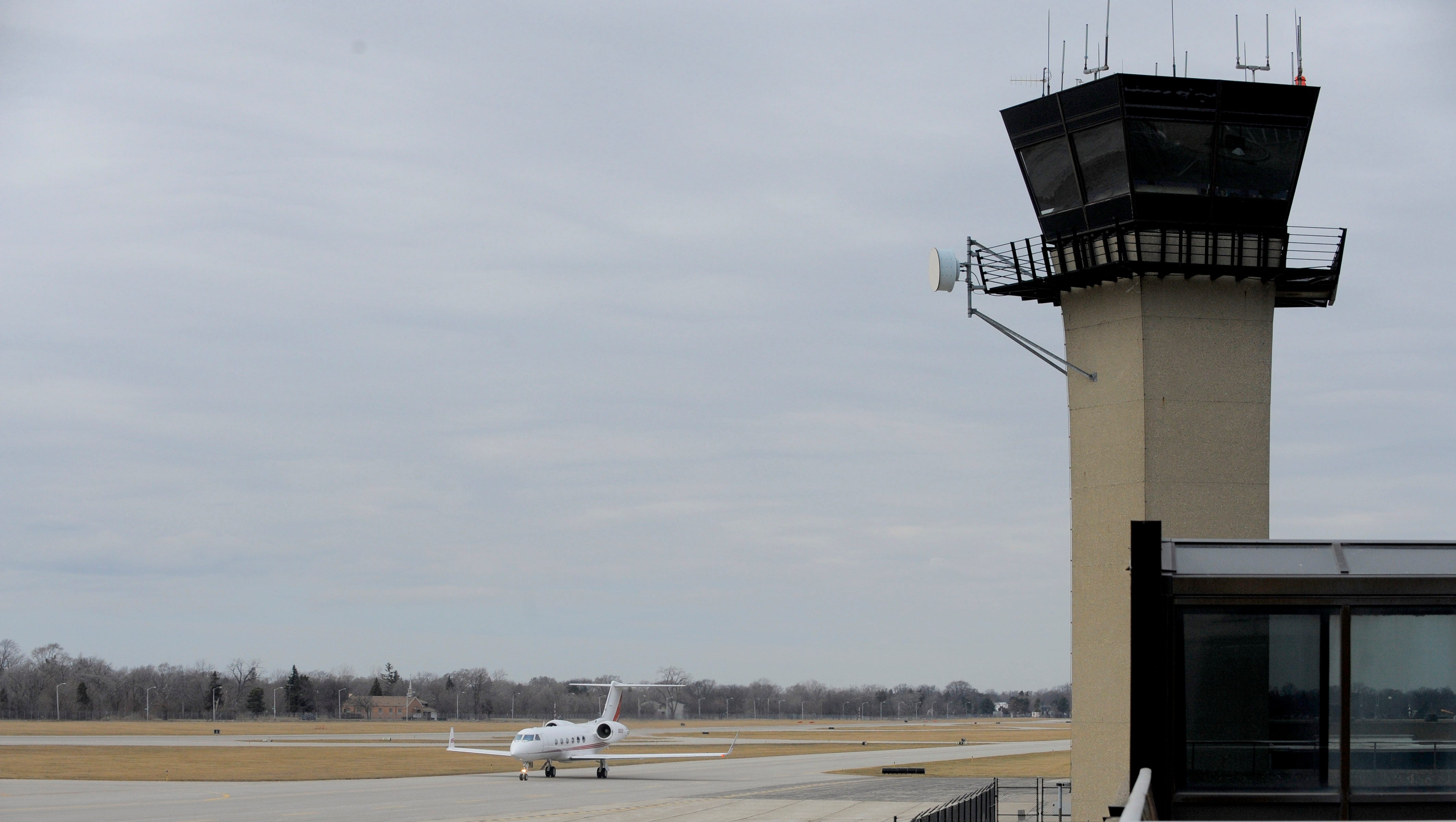 A plane taxis past the tower at Detroit City Airport.