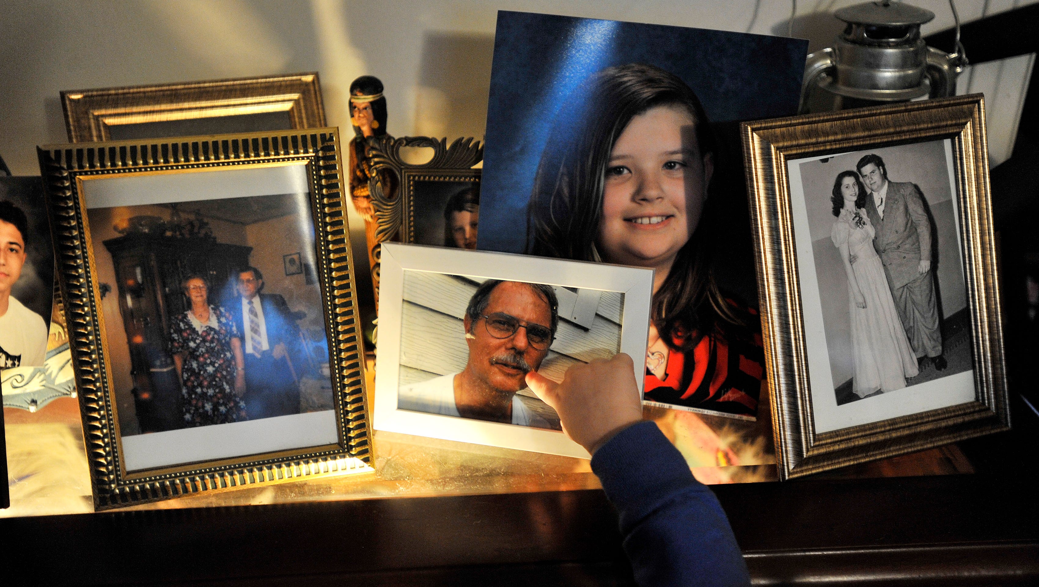 Layla Gutherie points to the photo of her grandfather, Chuck, who died of ALS last year.