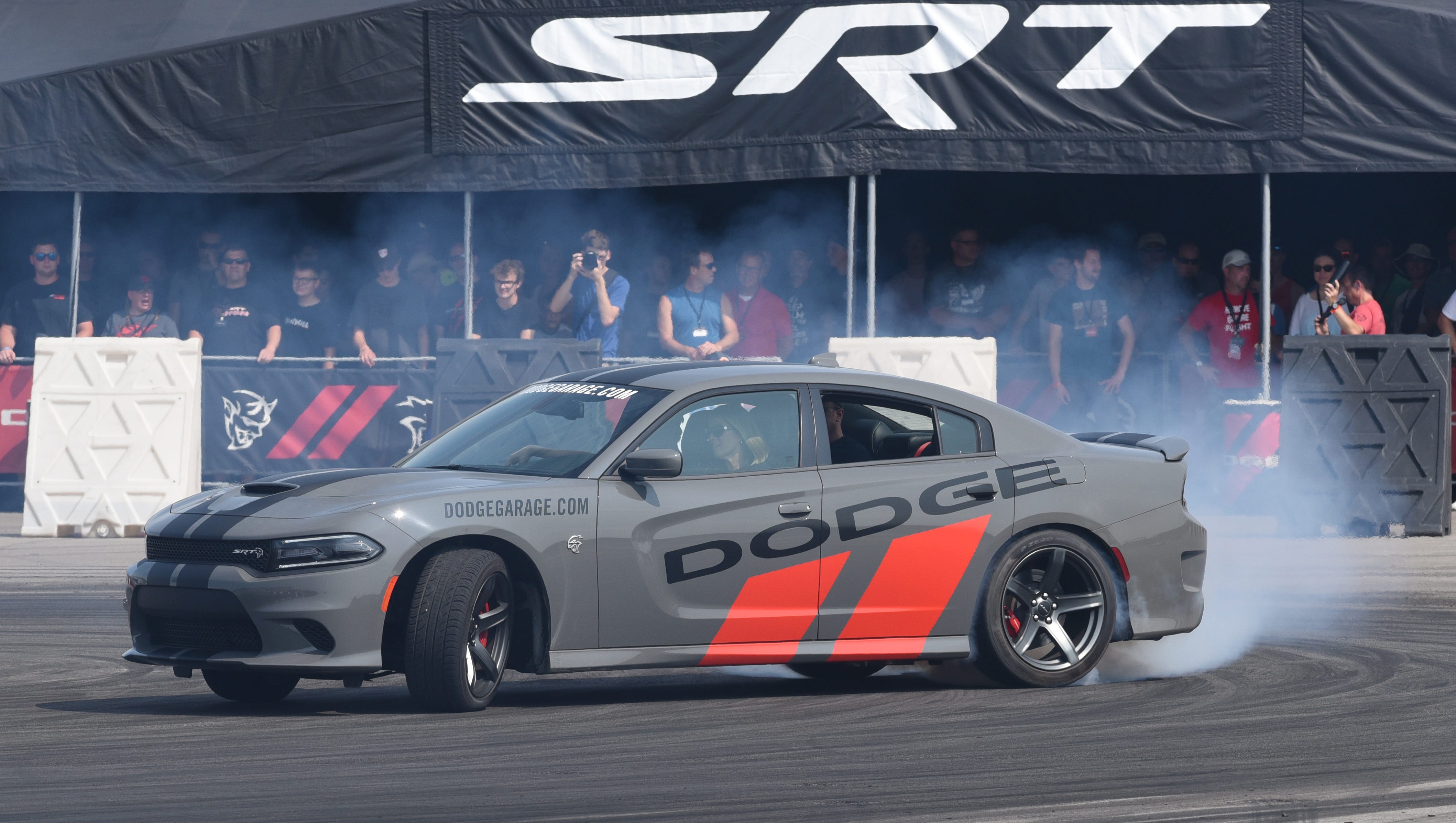 Fans watch the Dodge Charger during a drift ride.