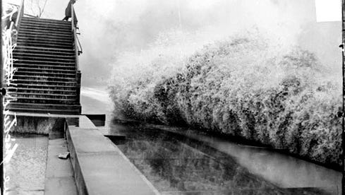 Waves break on the shore of Lake Michigan by Lincoln Park in Chicago, while a man watches from High Bridge in this photo published in the Chicago Daily News on Nov. 10, 1913.