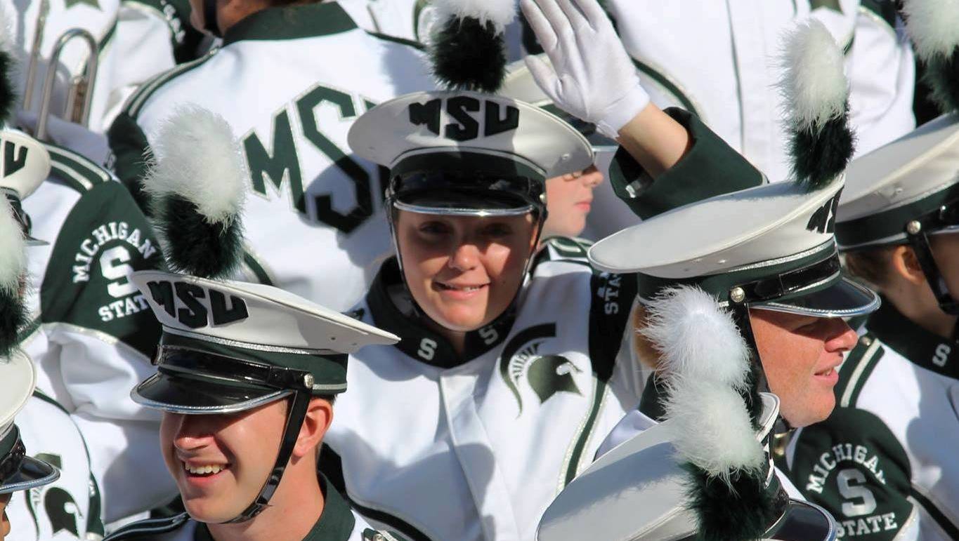 John Culp of Dearborn wanted to photograph his daughter Lindsay in the MSU band at Spartan Stadium,  but "trying to find her in a crowd of 300+ musicians, hair tucked up, all dressed alike, is challenging," he said.  During the "post-game shenanigans" he succeeded, drawing a wave from her after he yelled her name.